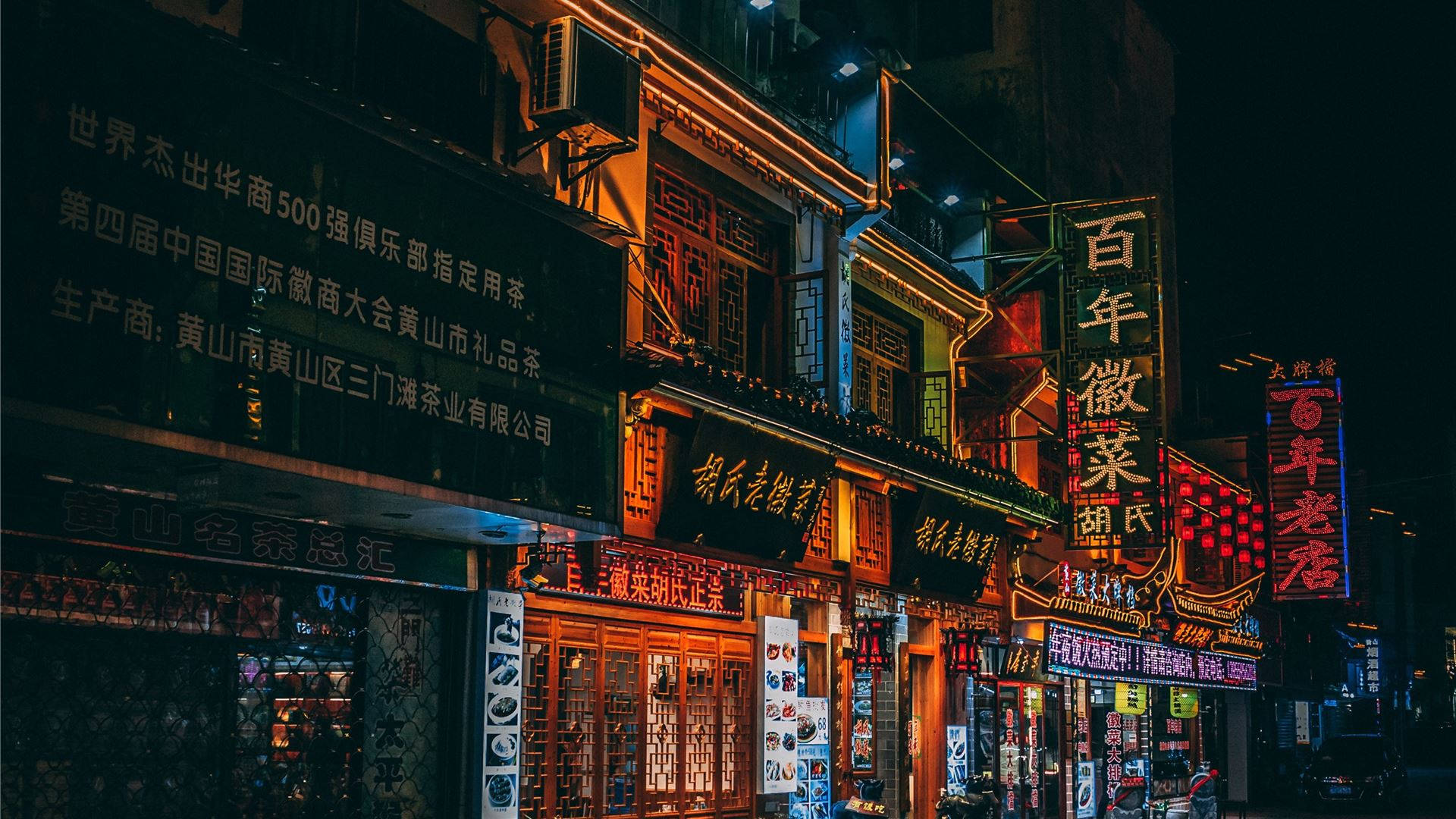 企業商業建築群 壁紙 — 充滿活力的霓虹燈招牌照亮了一條繁華的夜市街道，兩旁是傳統中式建築和閃爍的店鋪門面。