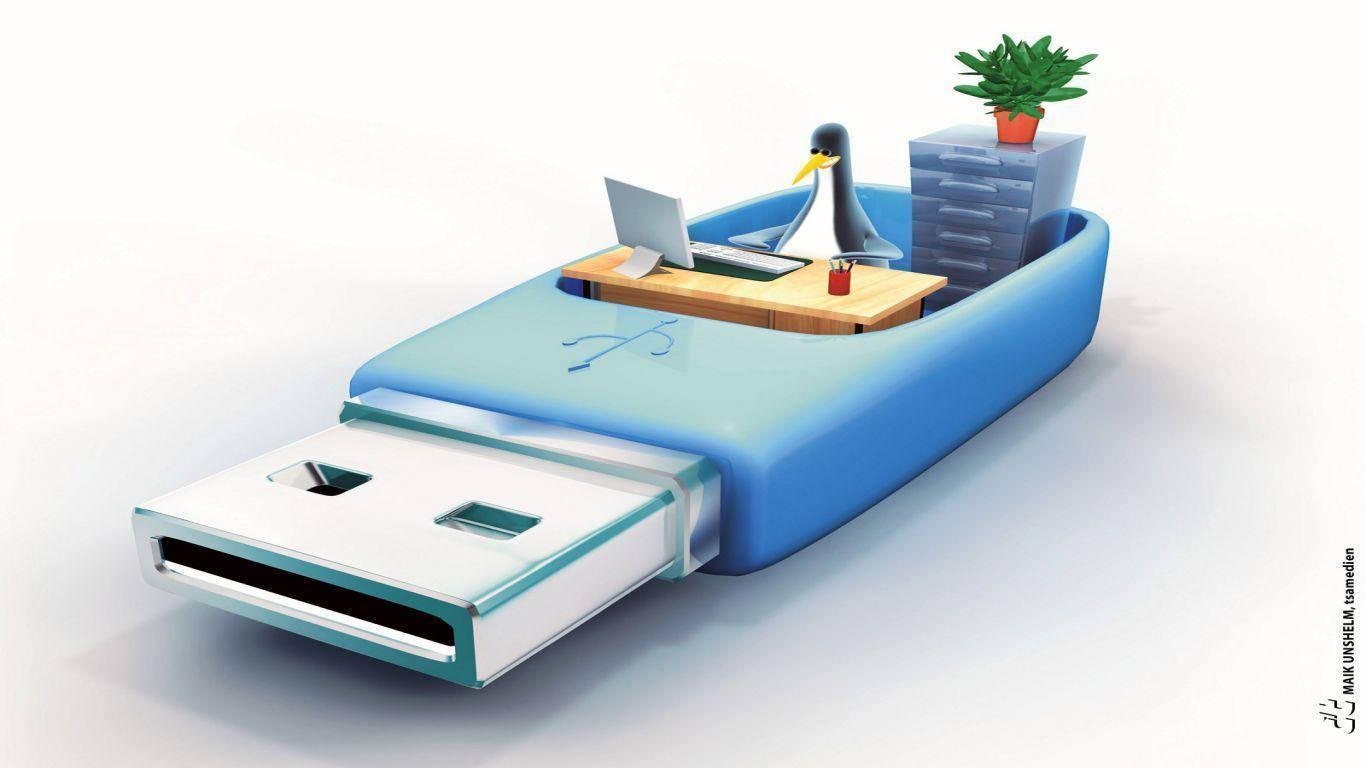 企鵝 USB 搞笑卡通 壁紙 — 一隻企鵝坐在藍色USB手指內的書桌前，拿著手提電腦和盆栽植物。