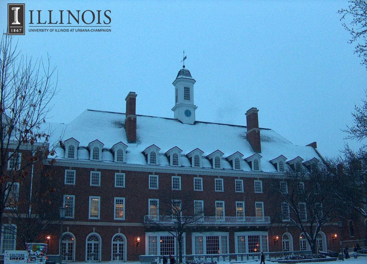 伊利諾大學建築在暮色中被白雪覆蓋，伴隨著光禿禿的樹木。