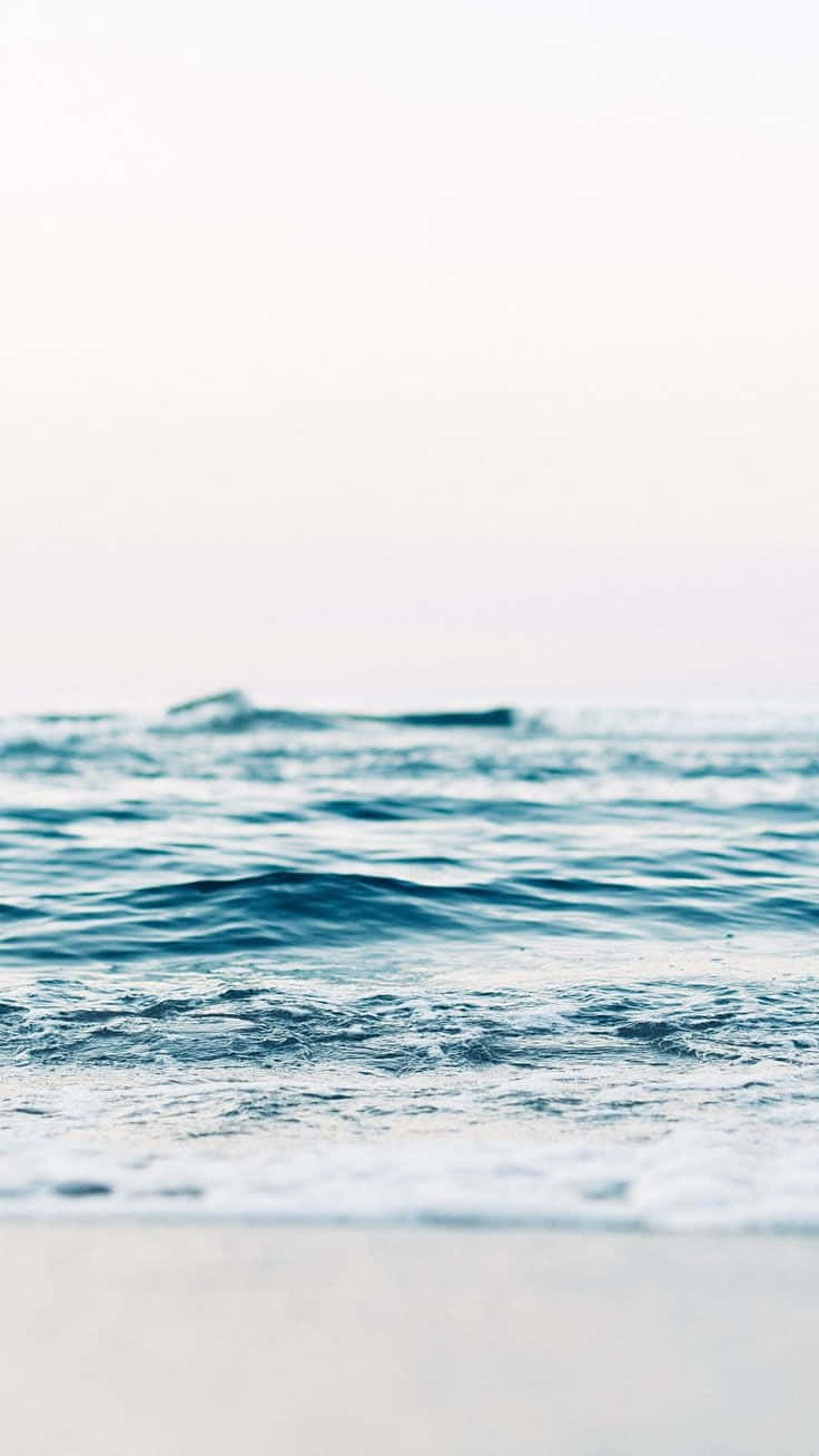 柔和的海浪沖刷沙灘，天空柔和