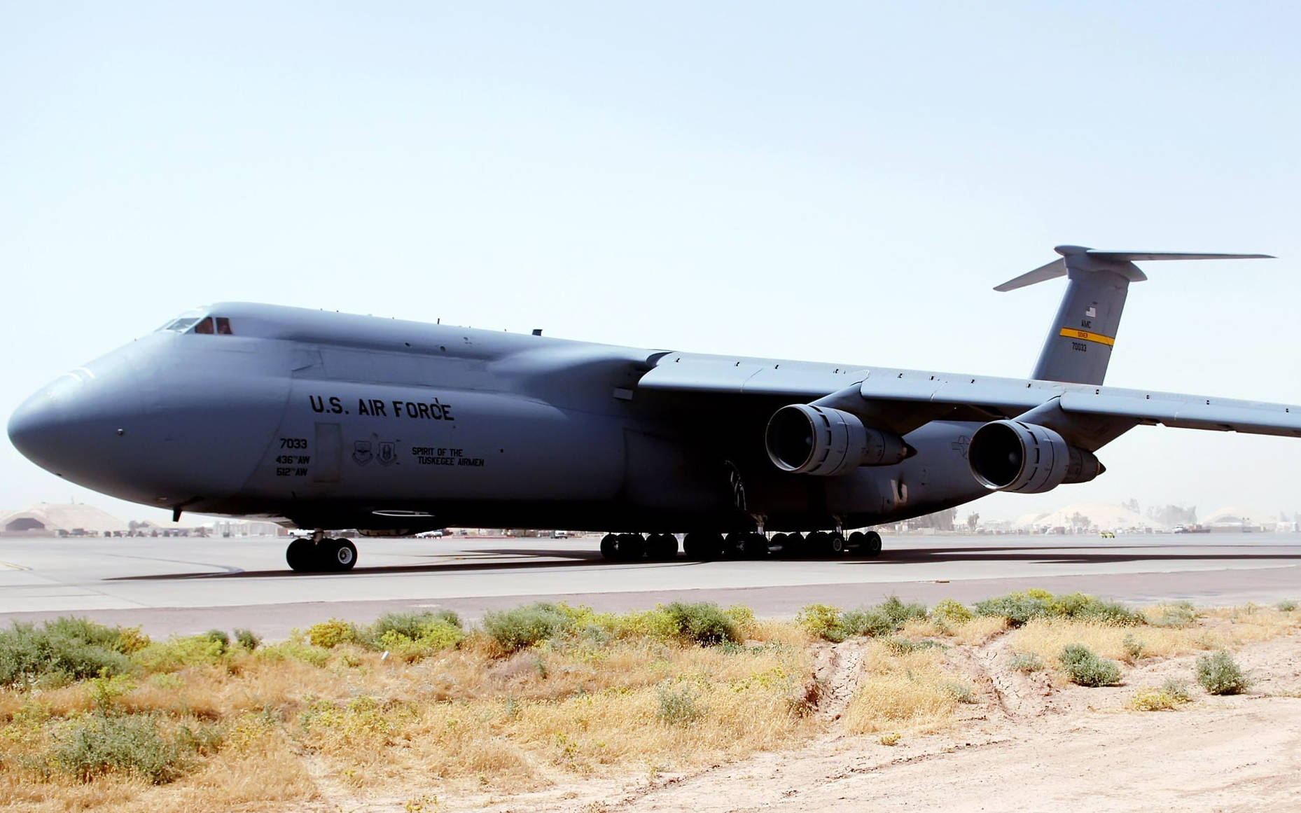 伊拉克巴爾德空軍基地洛克希德C-5銀河運輸機 壁紙 — 一架巨大的灰色美國空軍C-5銀河貨機停在沙漠跑道上，天空清澈湛藍。