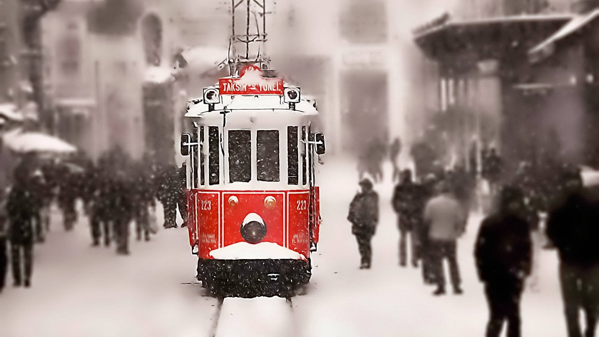伊斯坦堡紅色古董火車 壁紙 — 一輛紅色復古電車在積雪的市區街道上行駛，模糊的行人在飄落的雪中行走。