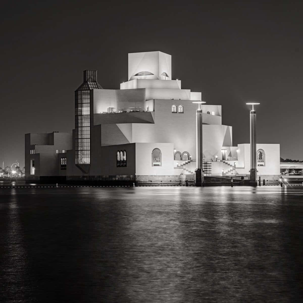 伊斯蘭藝術博物館黑白方塊壁紙 壁紙 — 一幅引人注目的黑白夜景照片，捕捉了一座現代建築奇蹟，被平靜水面上的倒影燈光照亮。
