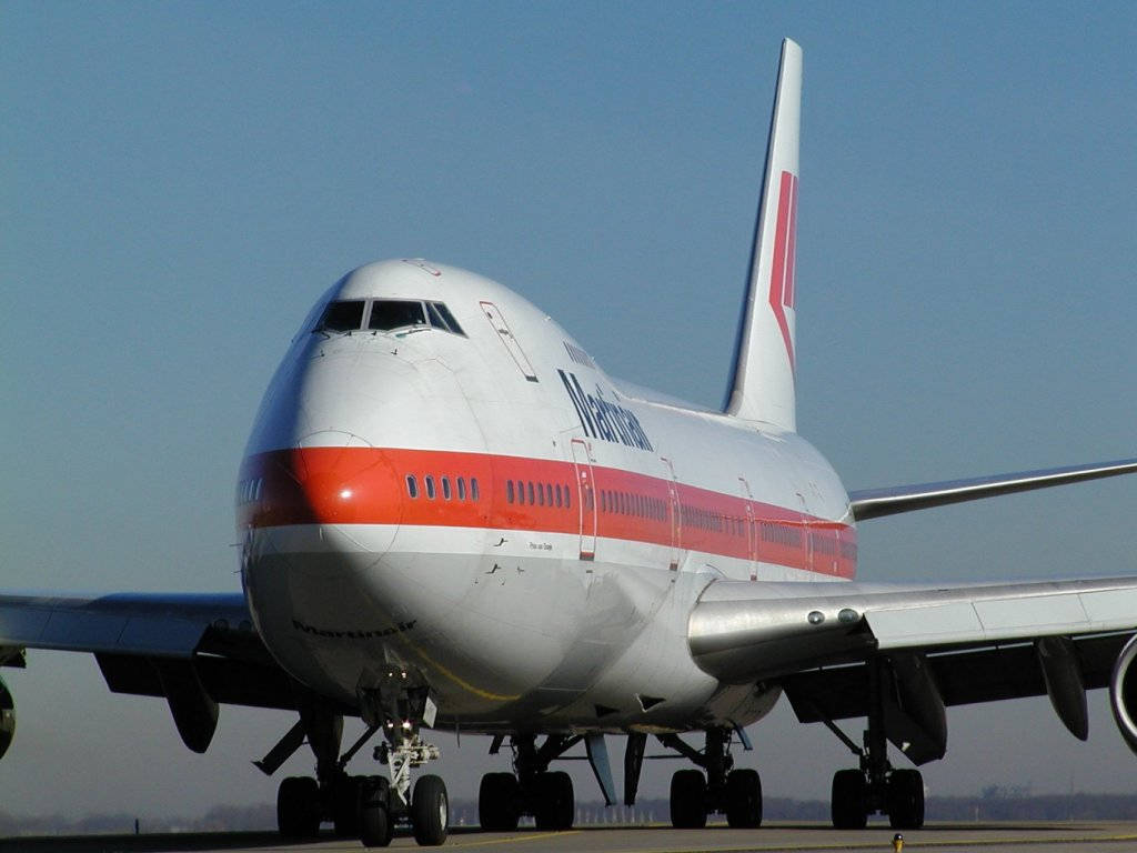 達美航空飛機在跑道上，起落架放下，天空清澈湛藍