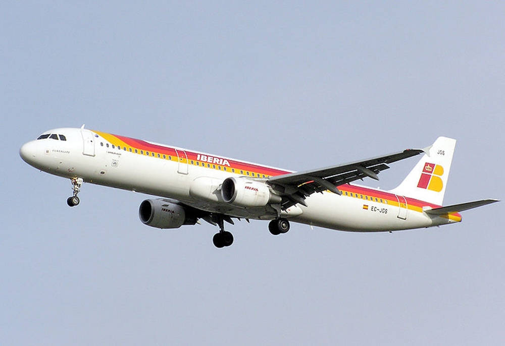 伊比利亞航空客機在飛行中，起落架放下，背景是晴朗的天空。
