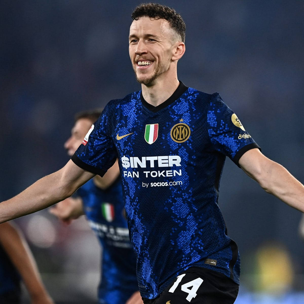 足球員身穿藍色球衣在夜間球場慶祝勝利