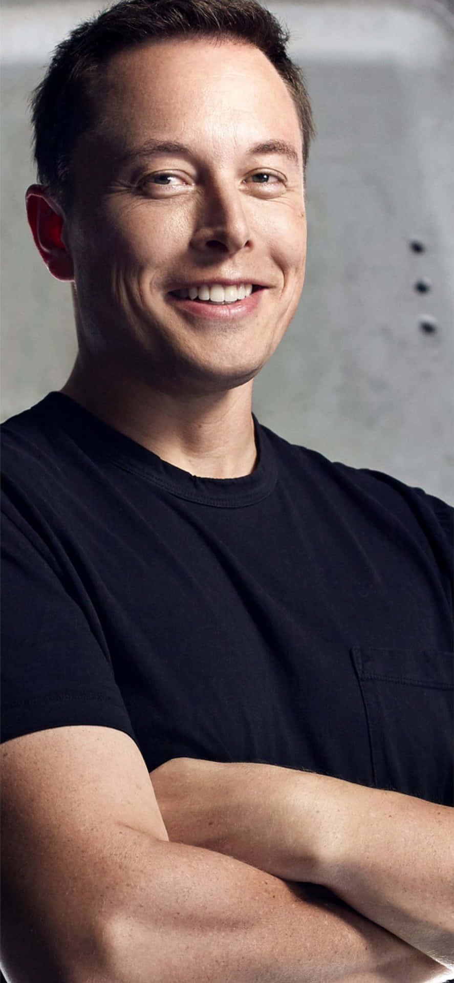 穿黑色T恤的男人微笑著雙臂交叉的攝影棚肖像