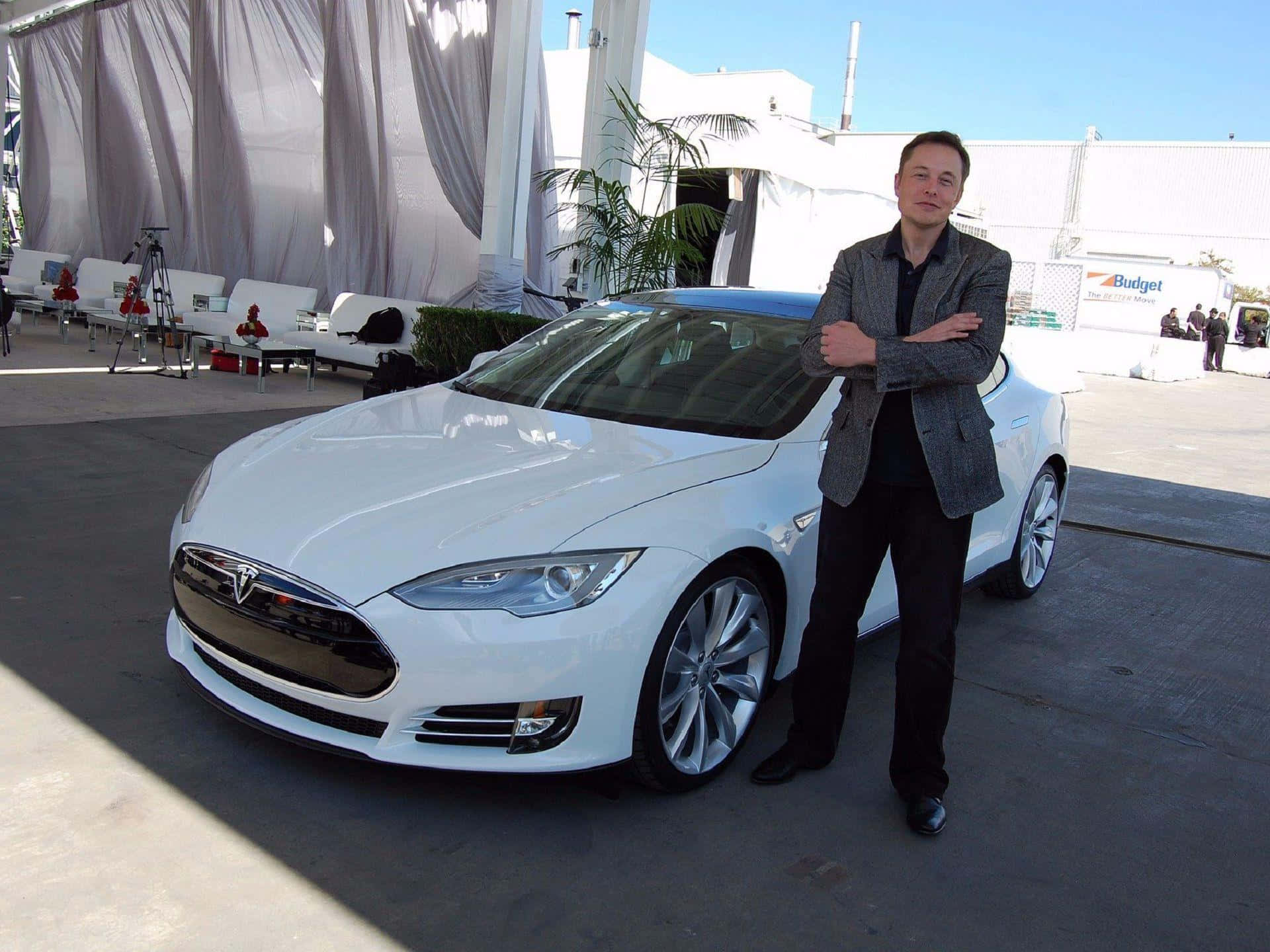 馬斯克 桌布 壁紙 — 伊隆·馬斯克自信地交叉雙臂，站在閃亮的白色Tesla Model S旁邊，在明亮的日光下。
