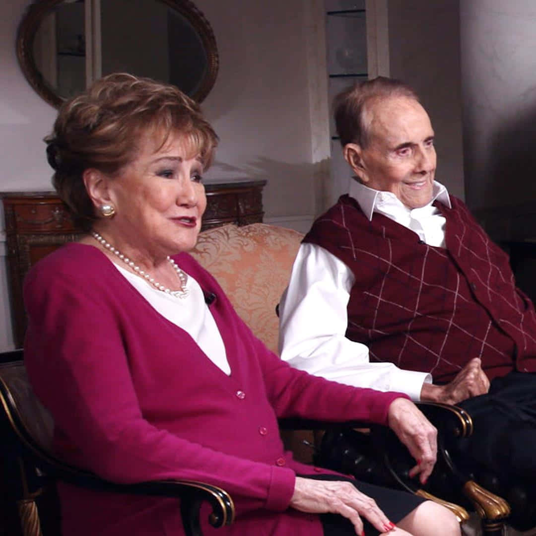 一對年長夫婦在室內優雅的椅子上微笑。