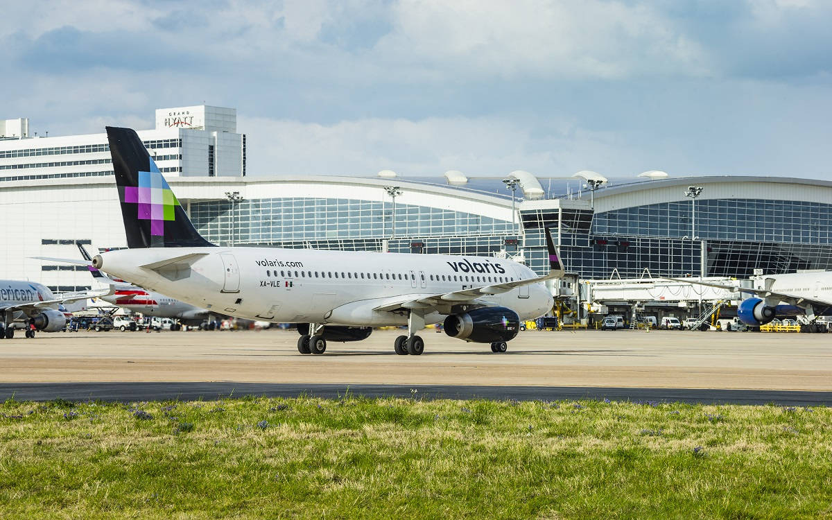 一架Volaris飛機在機場停機坪上，靠近航站樓