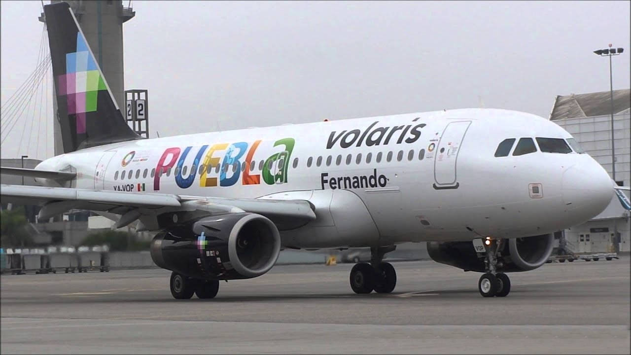灰色天空下機場停機坪上的Volaris飛機Puebla Fernando