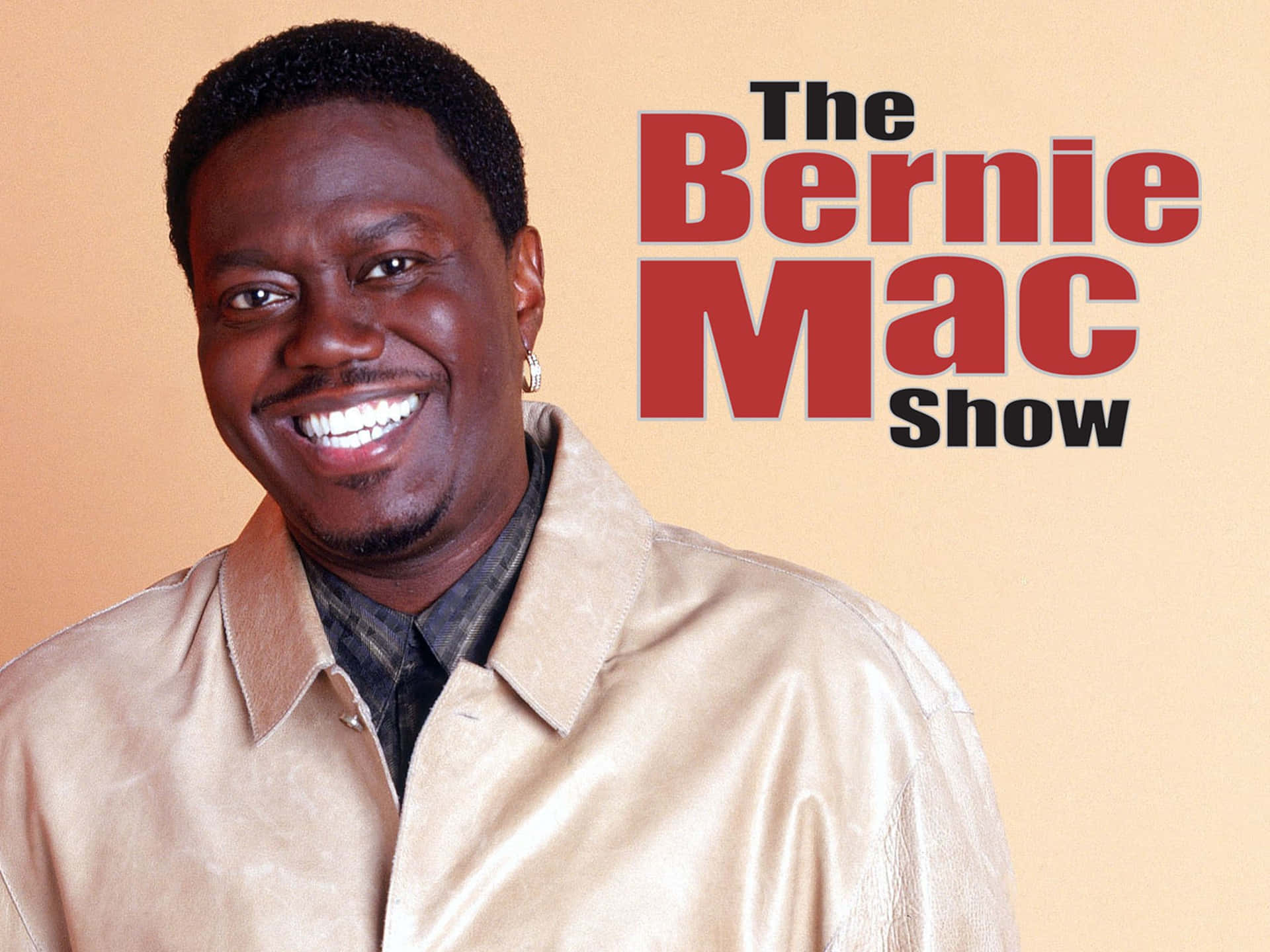 Bernie Mac 著住淺褐色外套，帶住節目標題文字微笑。