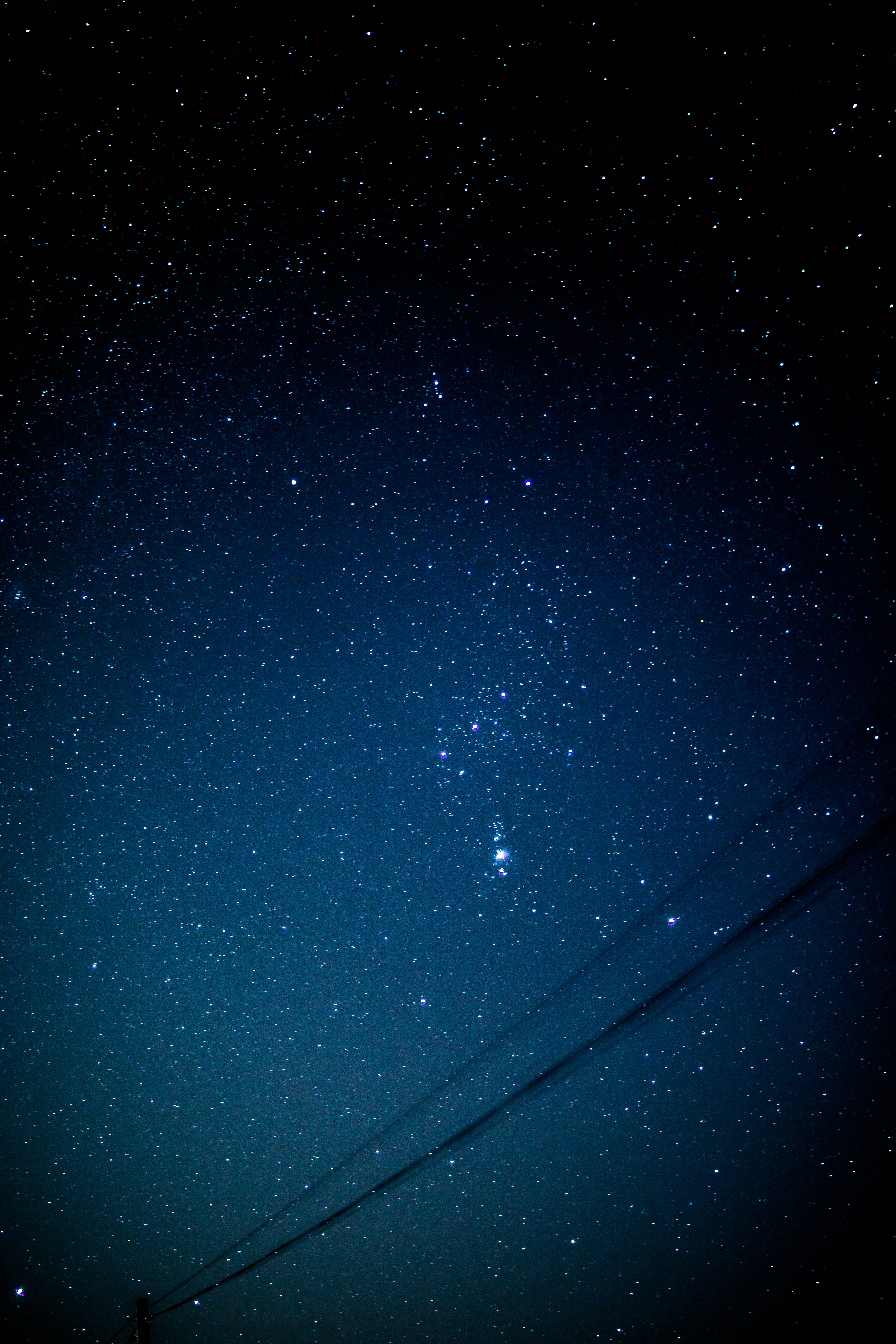 佈滿恆星的藍色星系 壁紙 — 繁星點點的夜空，帶有深藍色漸變和橫跨畫面的微弱電線。