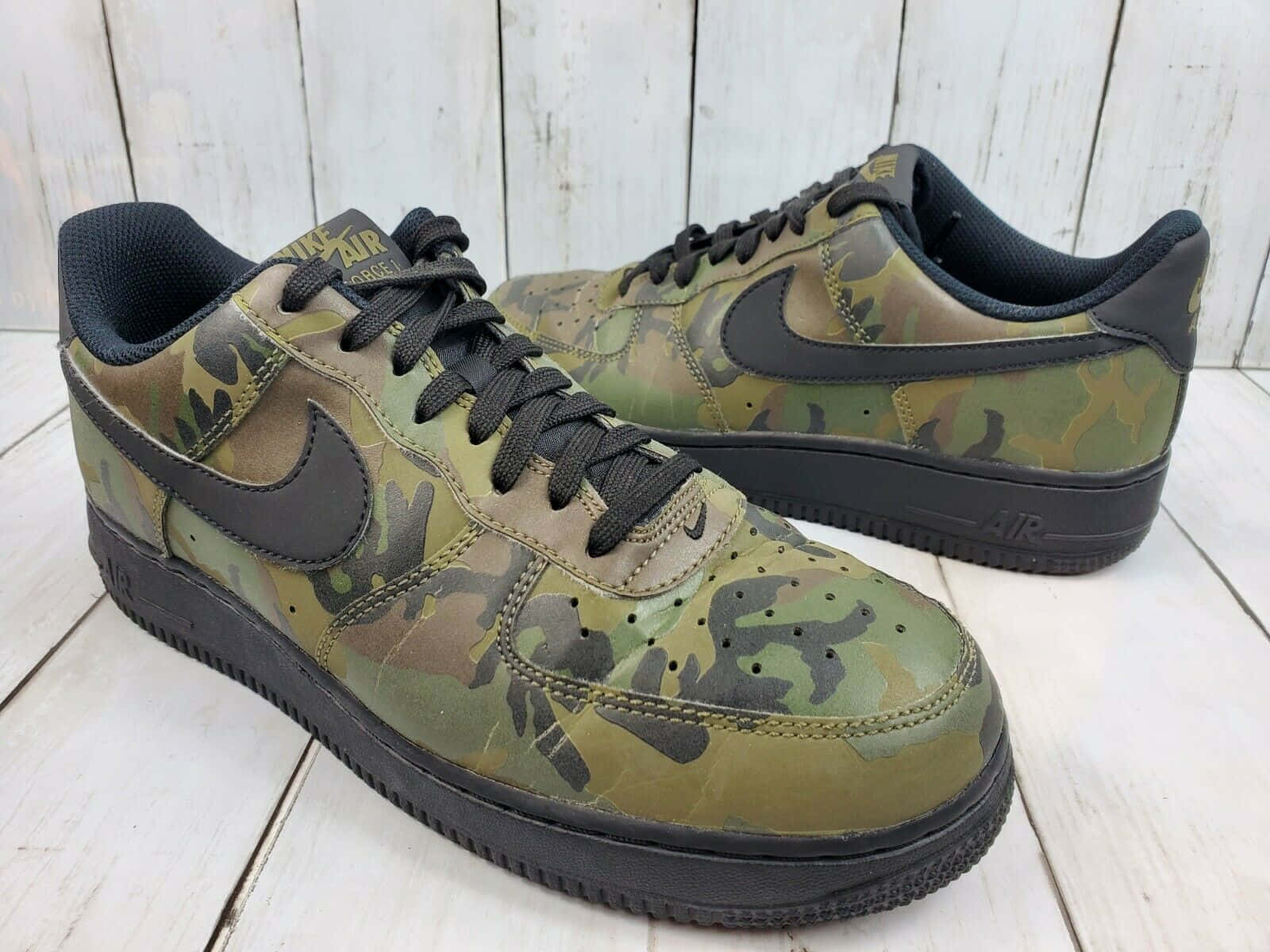 白色木板上嘅迷彩Nike Air Force 1運動鞋。