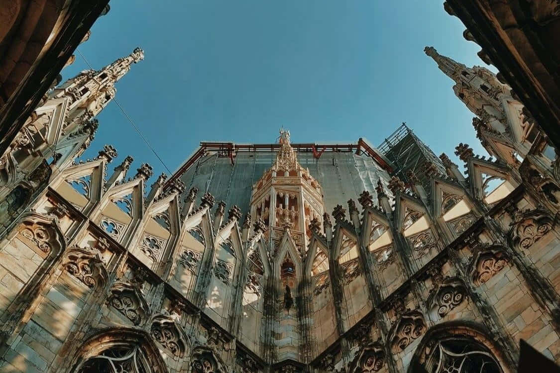 Gothic Architecture 桌布 壁紙 — 低角度視角捕捉到一座大教堂在晴朗藍天下複雜的哥德式建築，並可見修復腳手架。