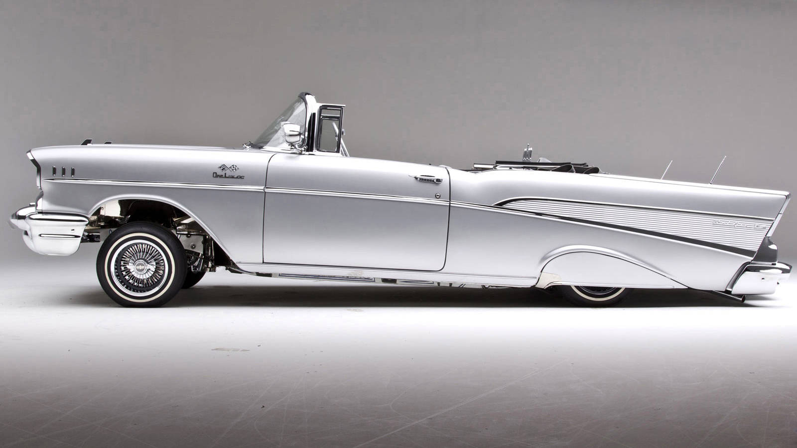 銀色1957年雪佛蘭Bel Air敞篷車，帶有鍍鉻細節和白牆輪胎。