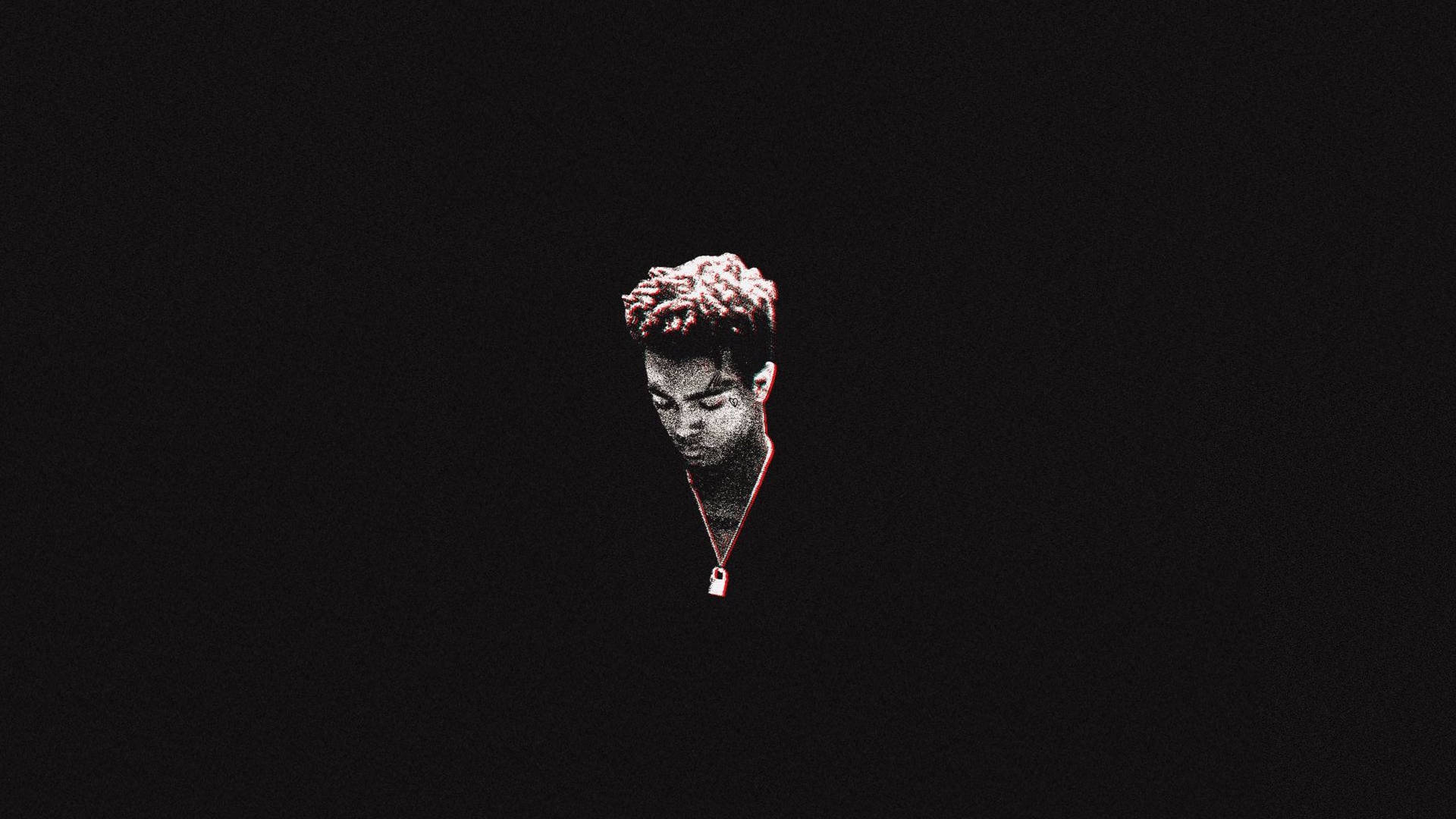 一個有著捲曲頭髮和紅色項鍊的人獨自站在黑暗中。