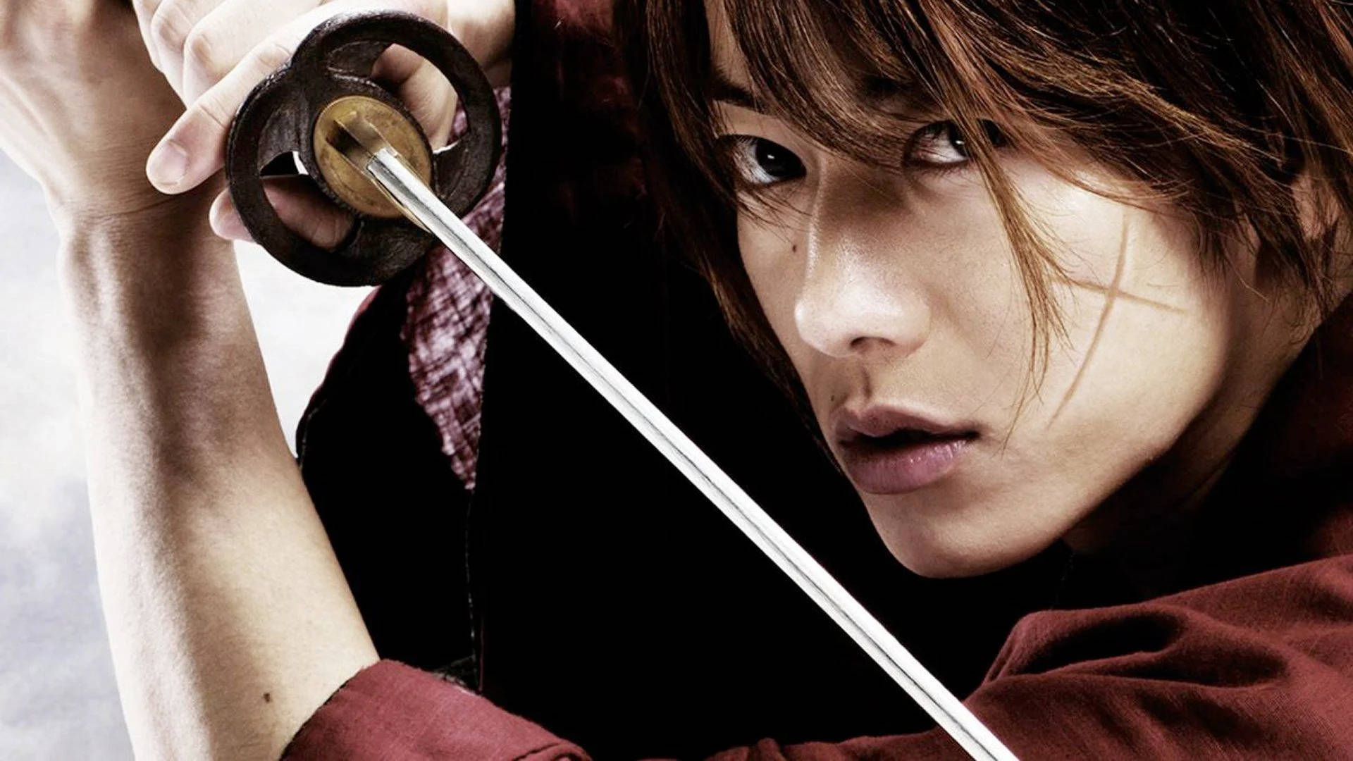 佐藤健飾演的浪客劍心 壁紙 — 一個專注的武士戰士緊握武士刀，眼神凌厲地直視前方，戲劇性的特寫鏡頭。