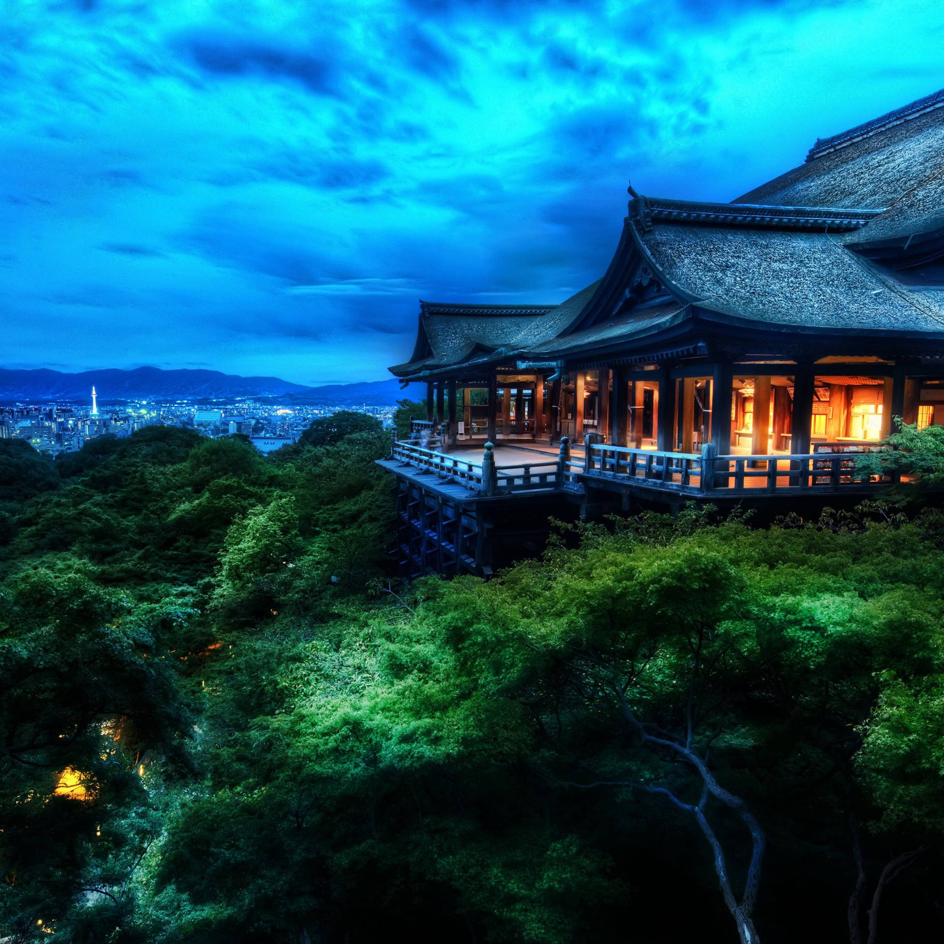 一座發光的寺廟在山上，被樹木環繞，俯瞰著黃昏時分的城市。