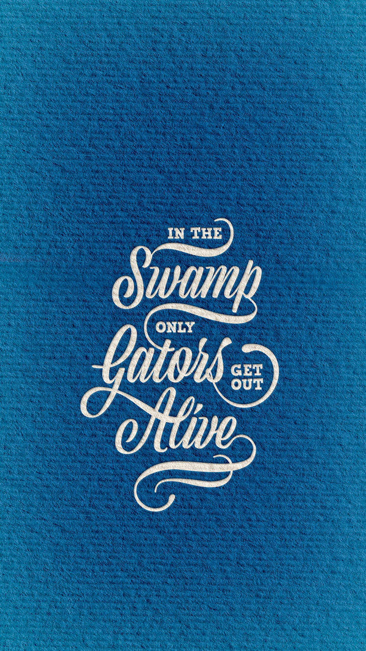 帶紋理的藍色布料上印有白色書法文字，內容為「In the Swamp Only Gators Get Out」。