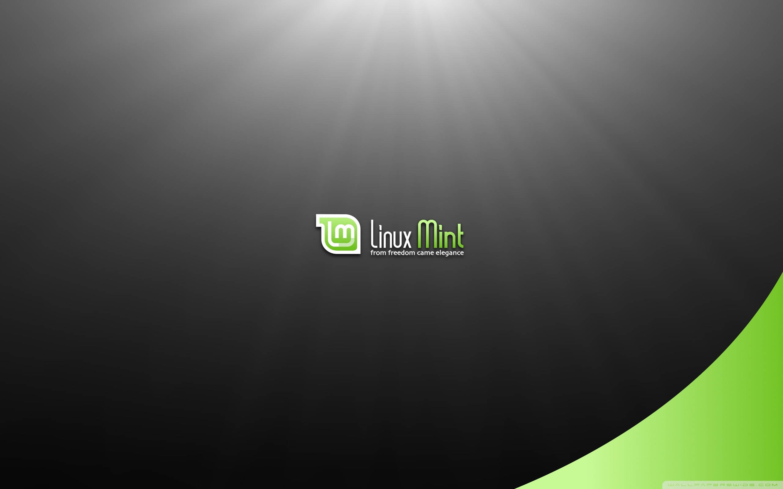 作業系統Linux Mint配發光燈光 壁紙 — Linux Mint 標誌居中於深色漸變背景上，帶有耀眼的光束和充滿活力的綠色彎曲點綴。