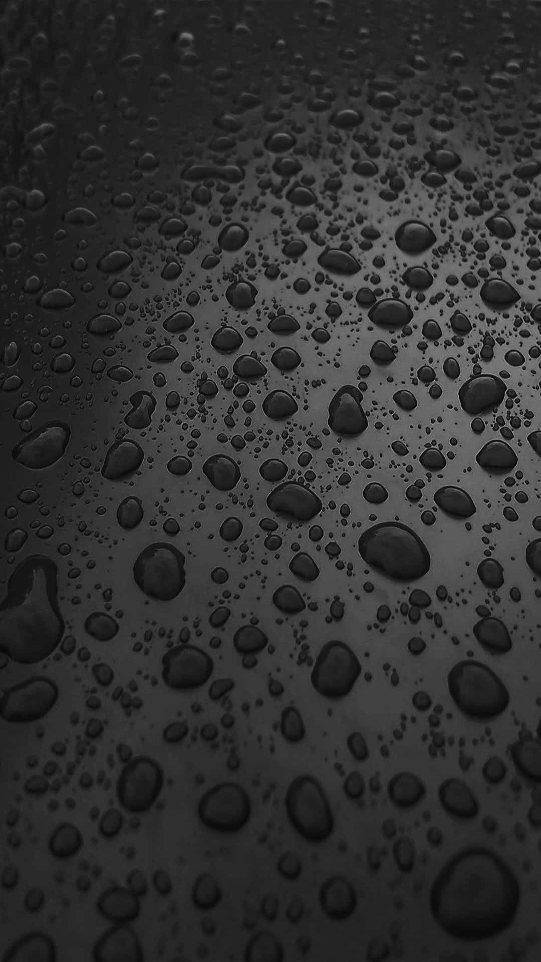閃爍的雨滴在深色光滑表面上，柔和漸變燈光。