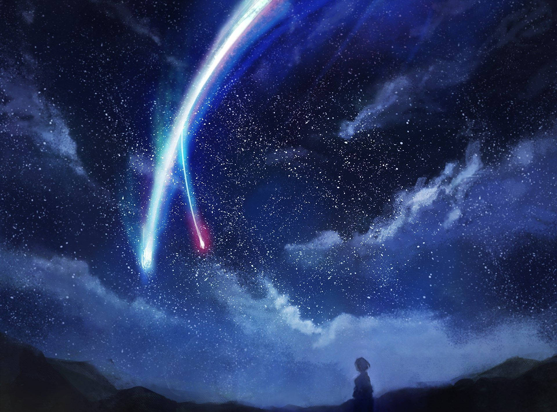 一個人觀看彩色彗星劃過星空夜空的剪影。
