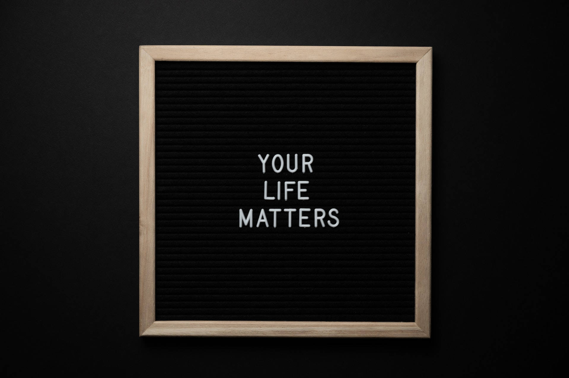 一個帶框的氈板，上面有白色字母的訊息「Your Life Matters」。