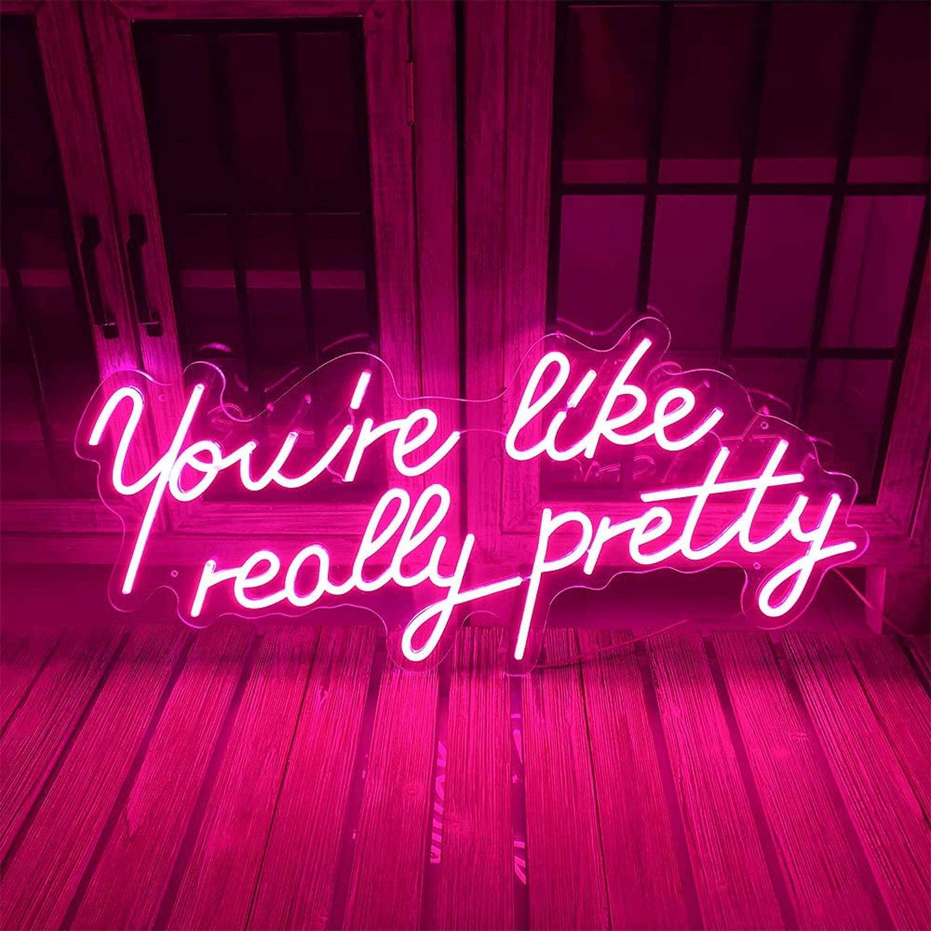 粉紅色霓虹燈牌，上面寫著 You're like really pretty，在木地板上