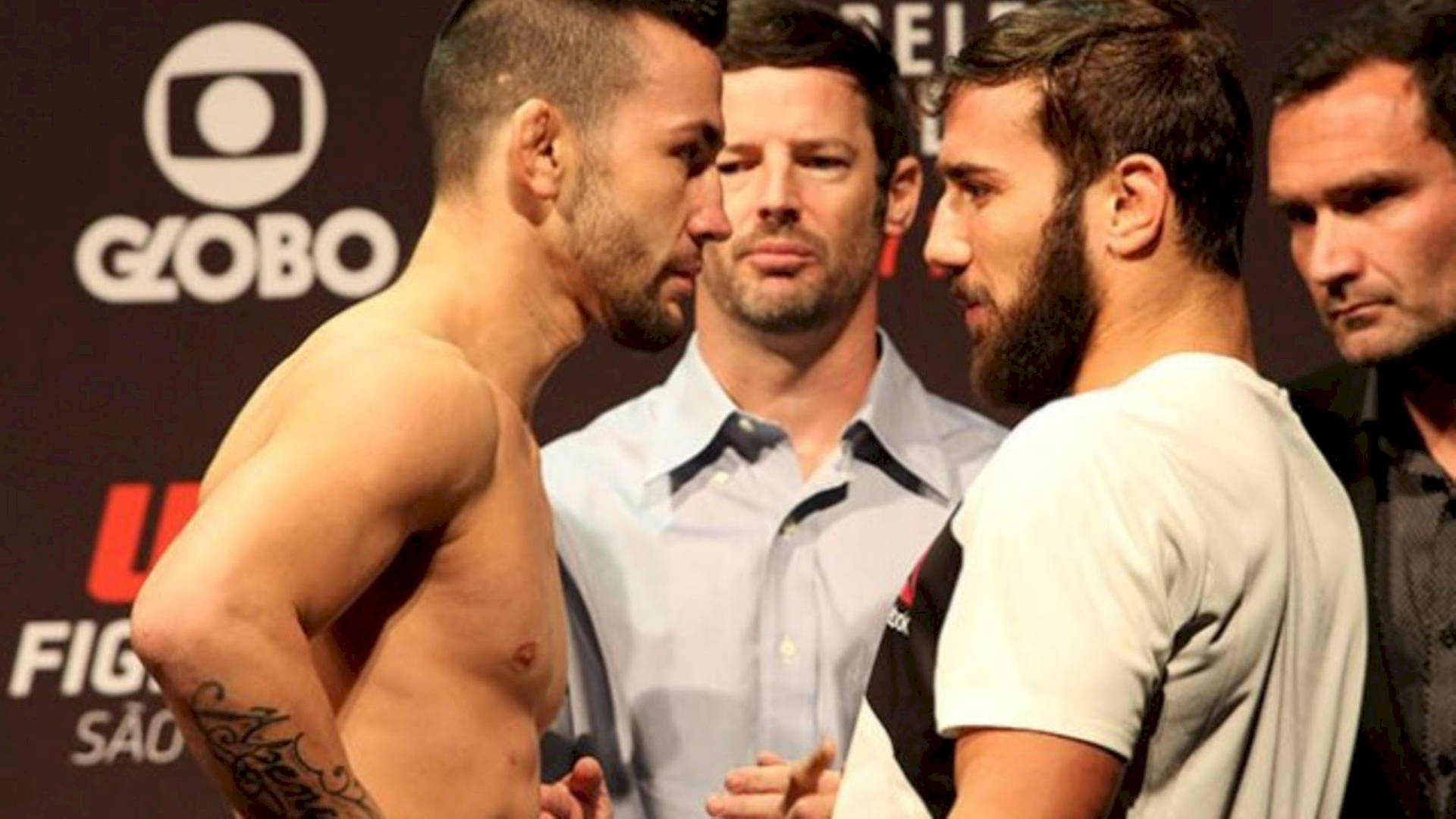 兩名男性MMA拳手在UFC稱重活動中，在官員身後對峙。