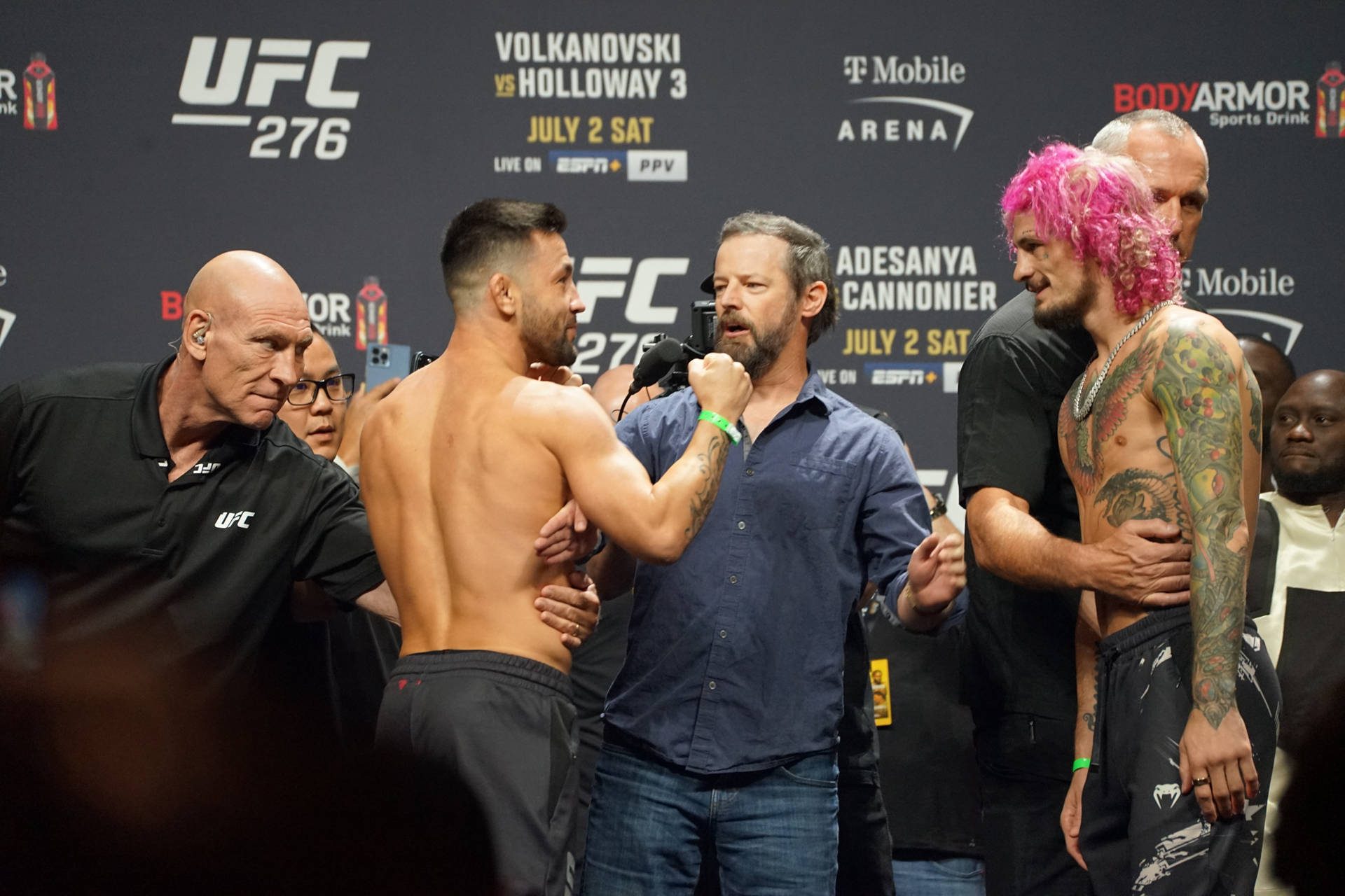 兩名UFC拳手在稱重活動中以粉紅色頭髮和紋身互相對峙。