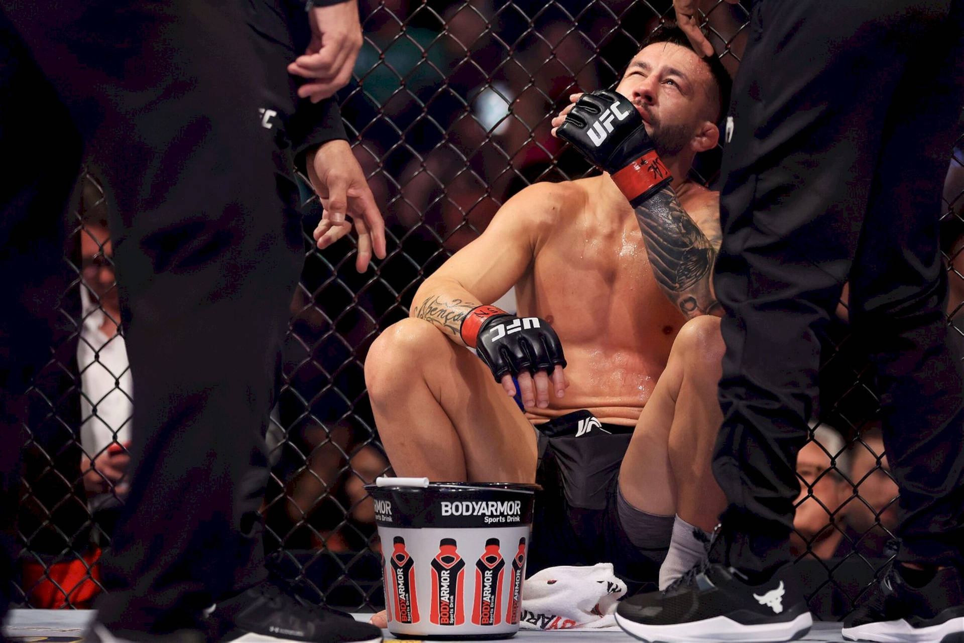 筋疲力竭的MMA拳手在八角籠內比賽後飲水。