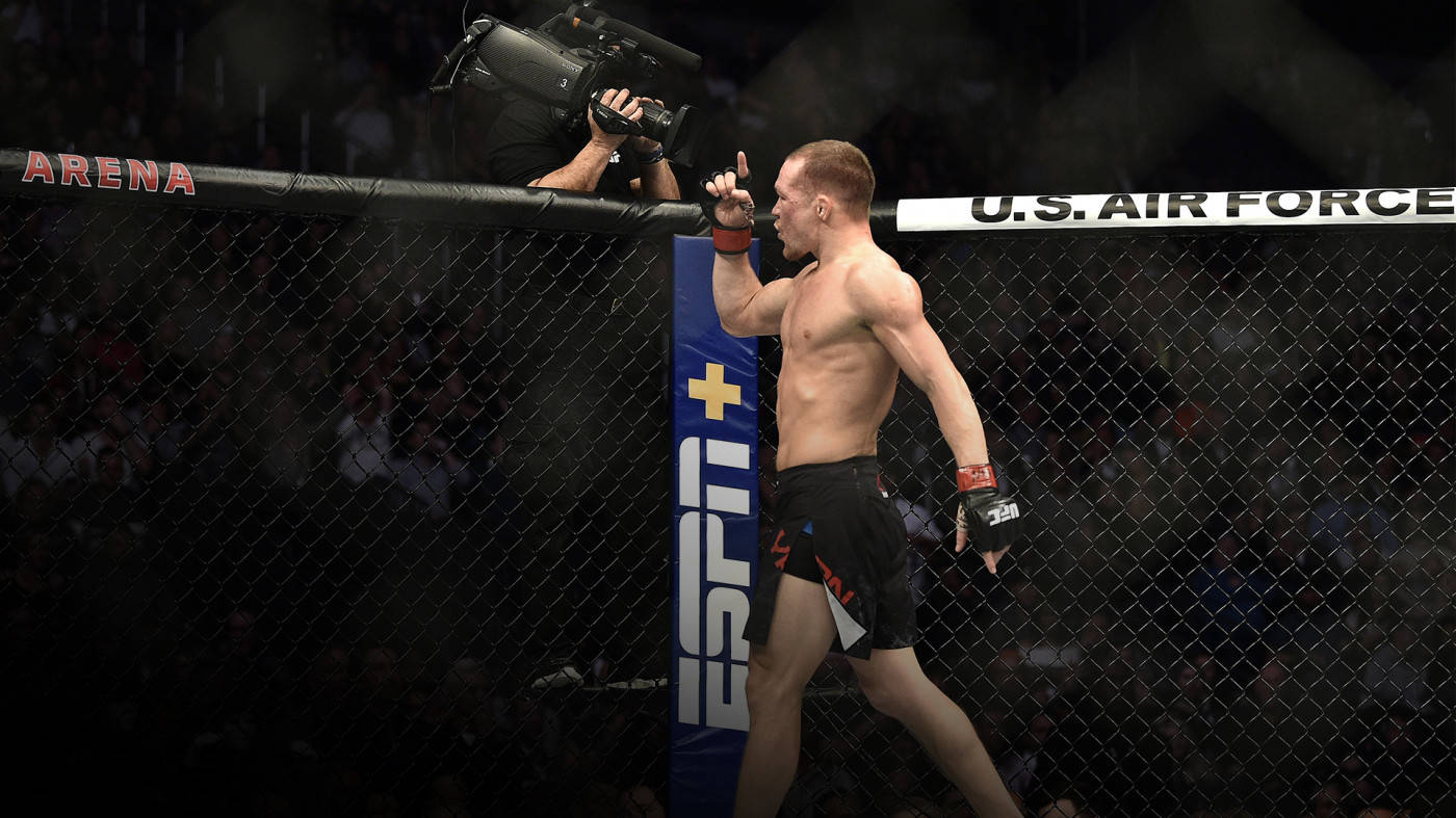 MMA拳手在八角籠內慶祝勝利，帶有ESPN和美國空軍標誌。