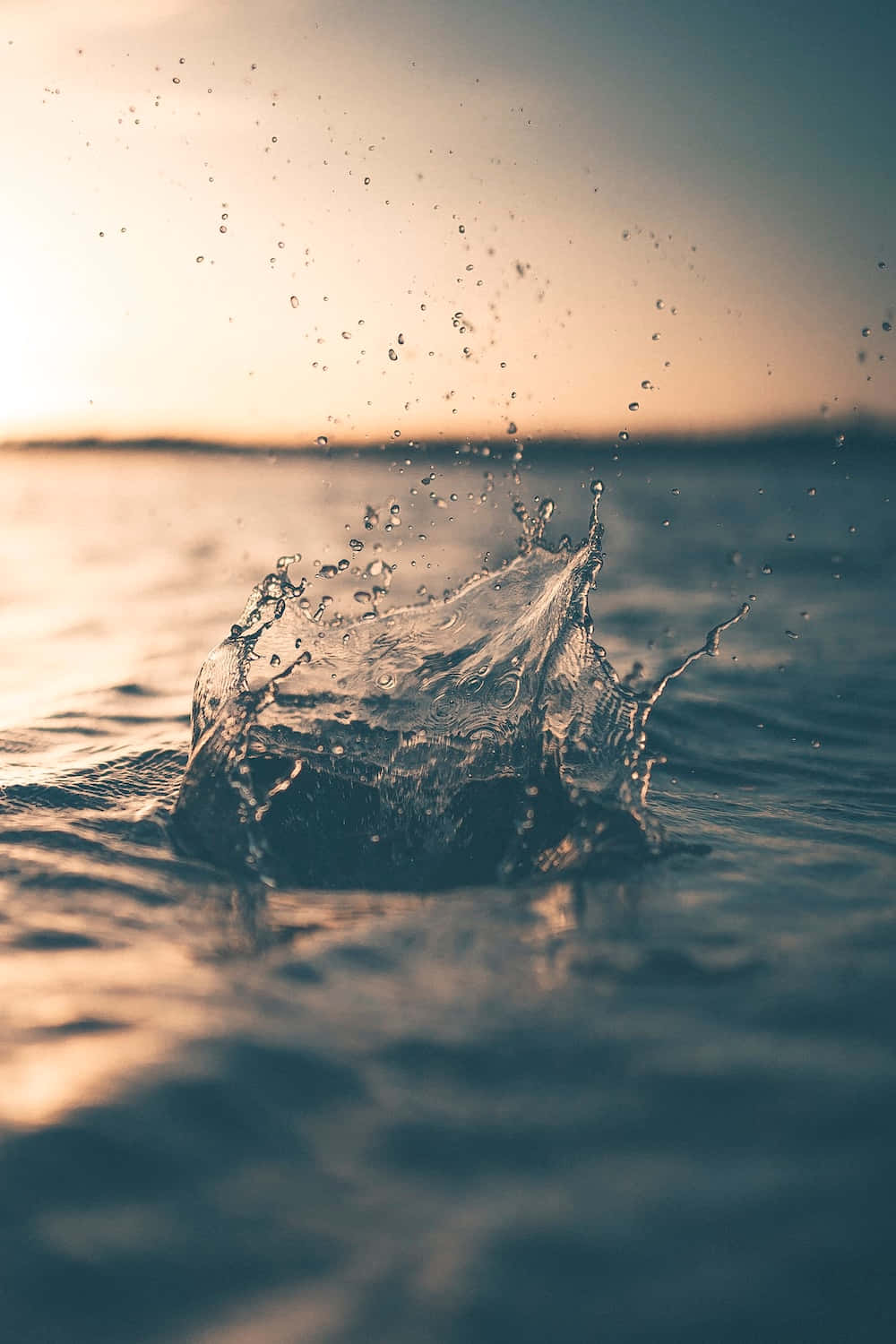 日落時的水花在海面上反射金色光芒