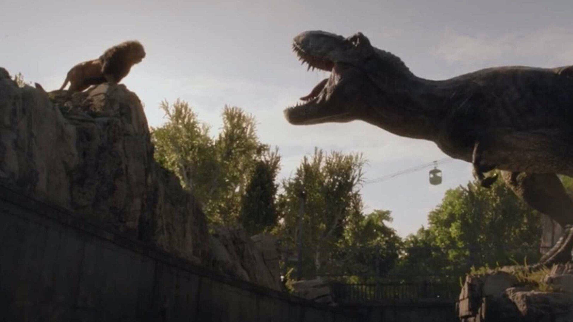 《侏羅紀世界：統霸天下》恐龍對獅子 壁紙 — 一頭獅子棲息在岩石突出處，面對著一個在茂密公園中咆哮的暴龍，頭頂有纜車經過。