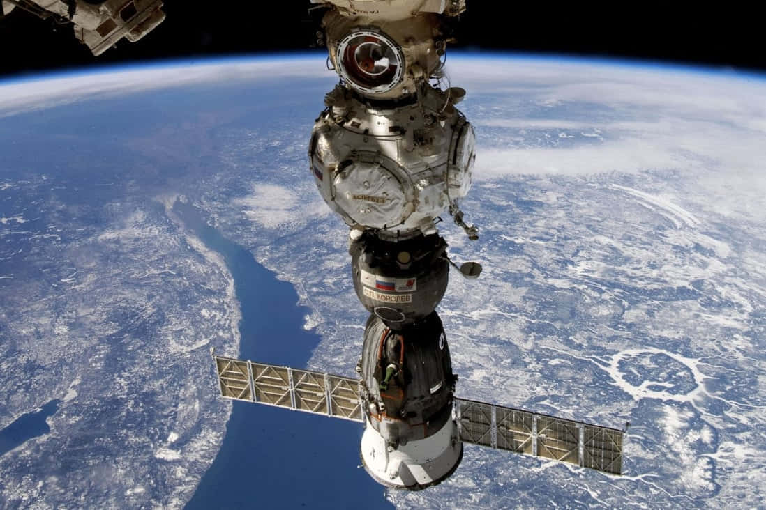 International Space Station 桌布 壁紙 — 俄羅斯太空站模組的詳細視圖，太陽能電池板向外延伸，背景是地球彎曲的藍白表面。