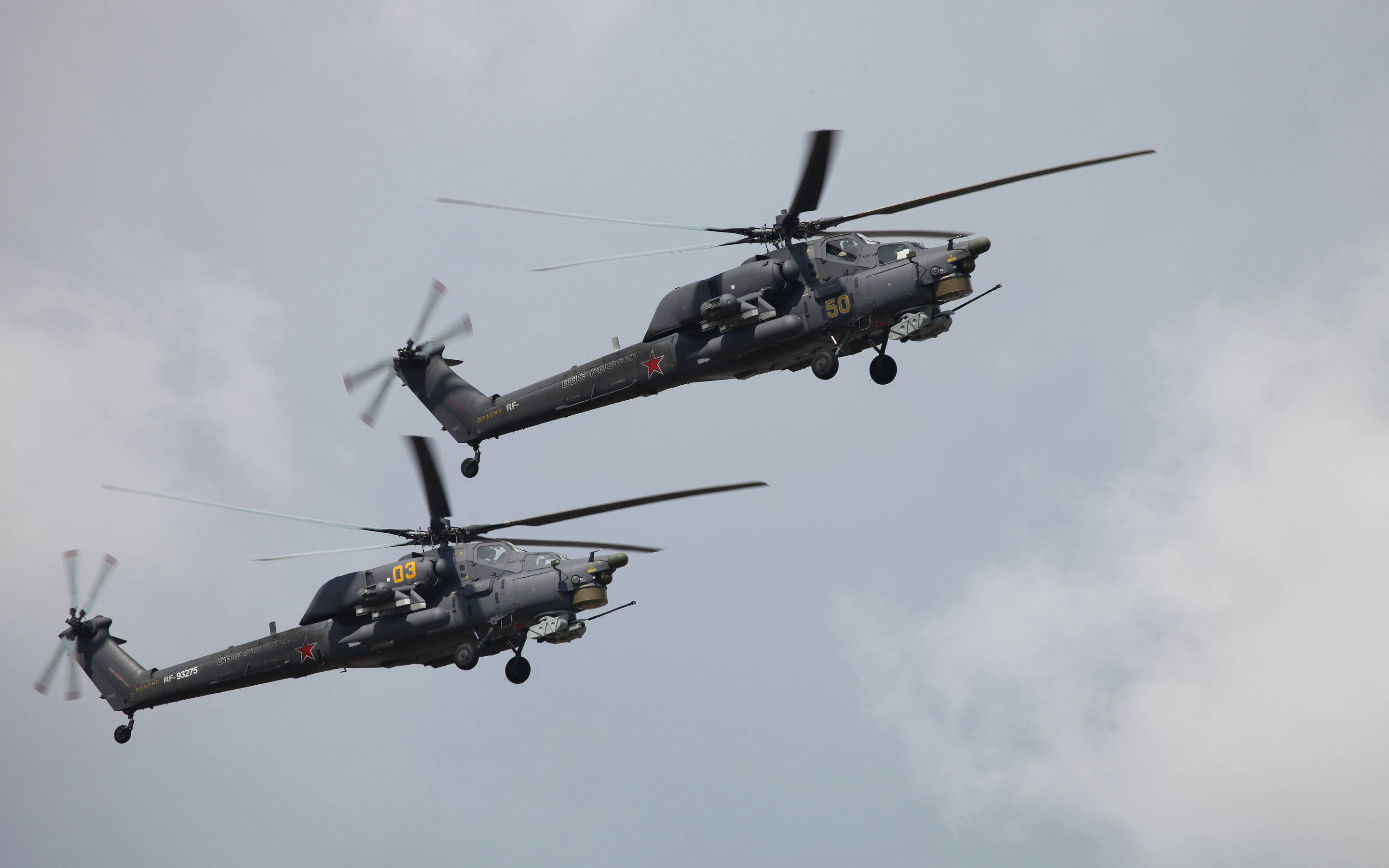 俄羅斯空軍 Mi-28 壁紙 — 兩架帶有紅色星形標誌的灰色軍用直升機在陰天背景下編隊飛行。