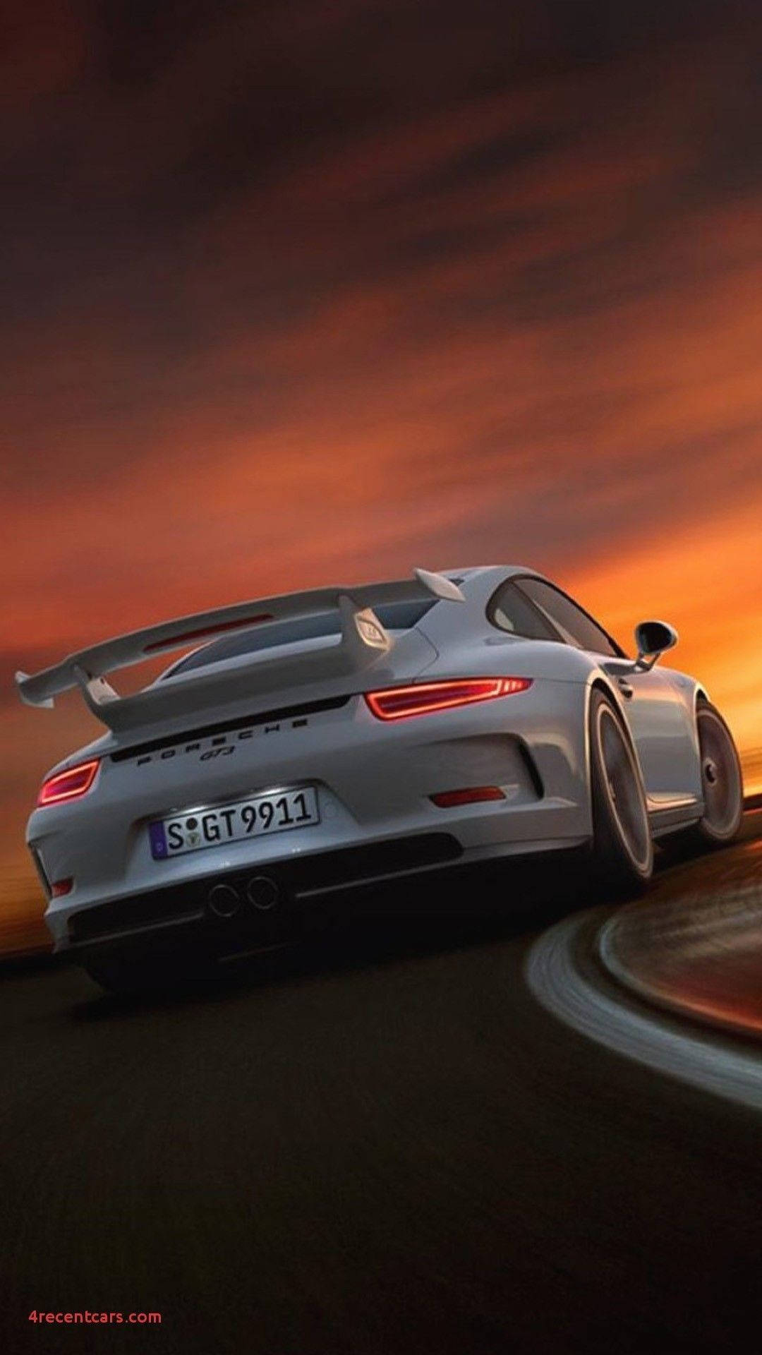 銀色保時捷911 GT3在日落時分的彎曲道路上疾馳。