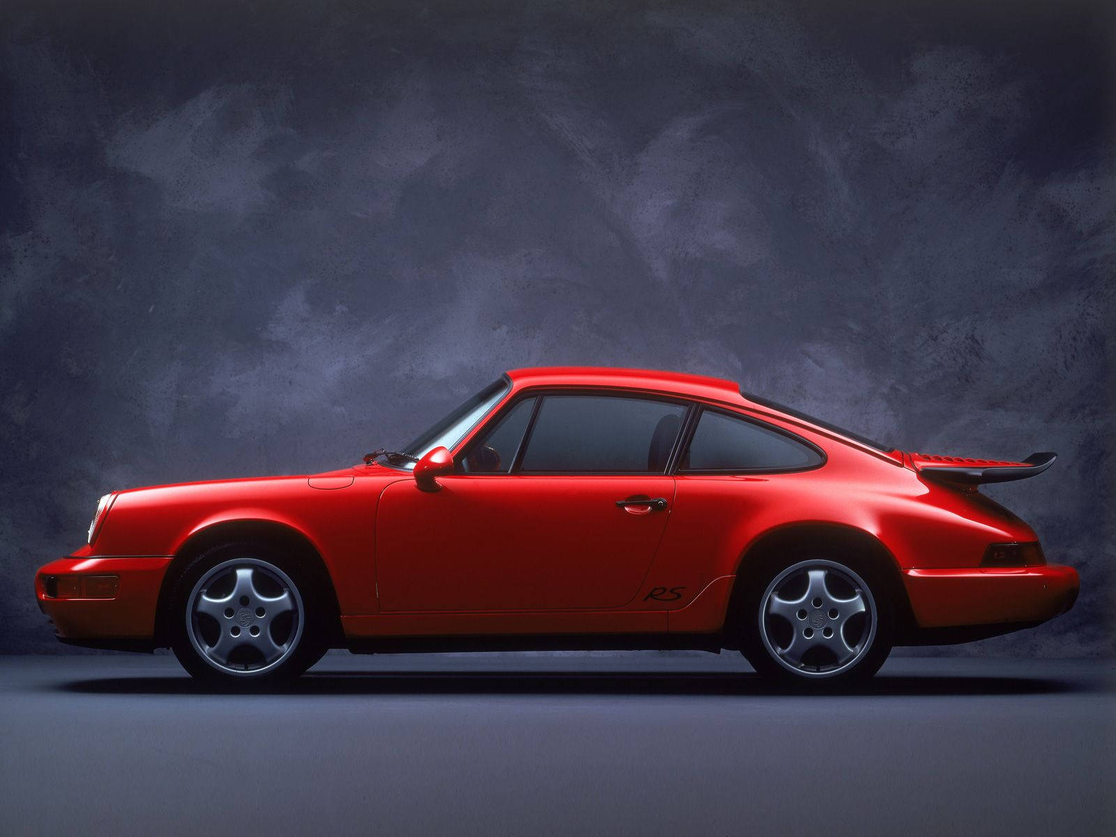 紅色保時捷911 Turbo S跑車在工作室中，背景為深灰色。