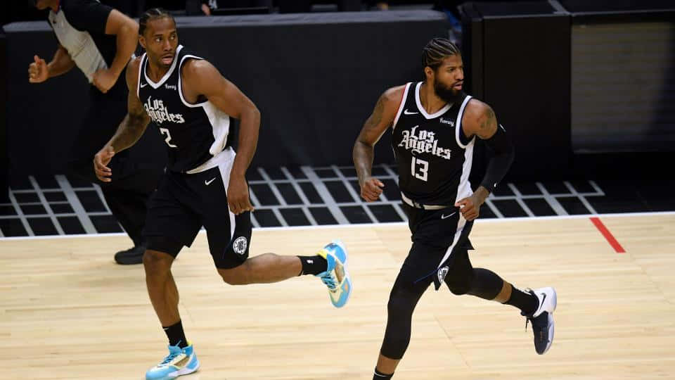 兩名籃球運動員在比賽中在球場上奔跑。