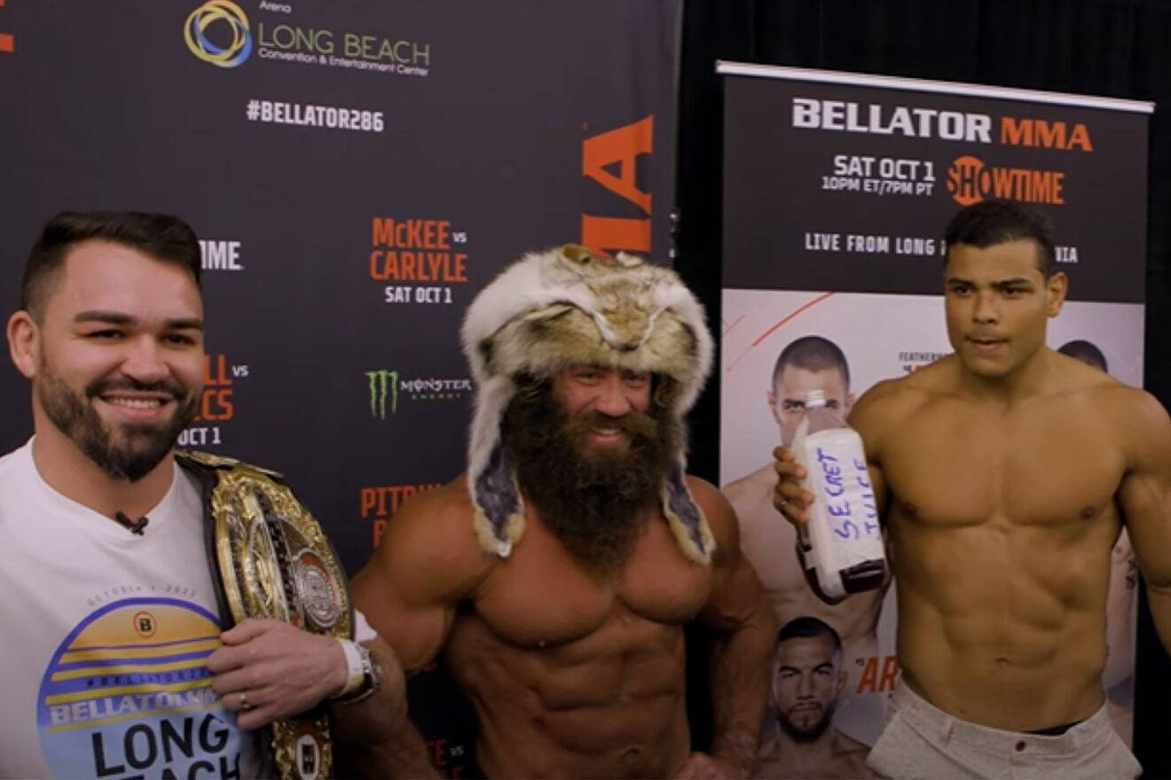 保羅·科斯塔於Bellator賽事 壁紙 — 三位肌肉發達的MMA拳手在Bellator活動中擺姿勢，一人戴著毛帽並拿著瓶子，另一人展示冠軍腰帶。