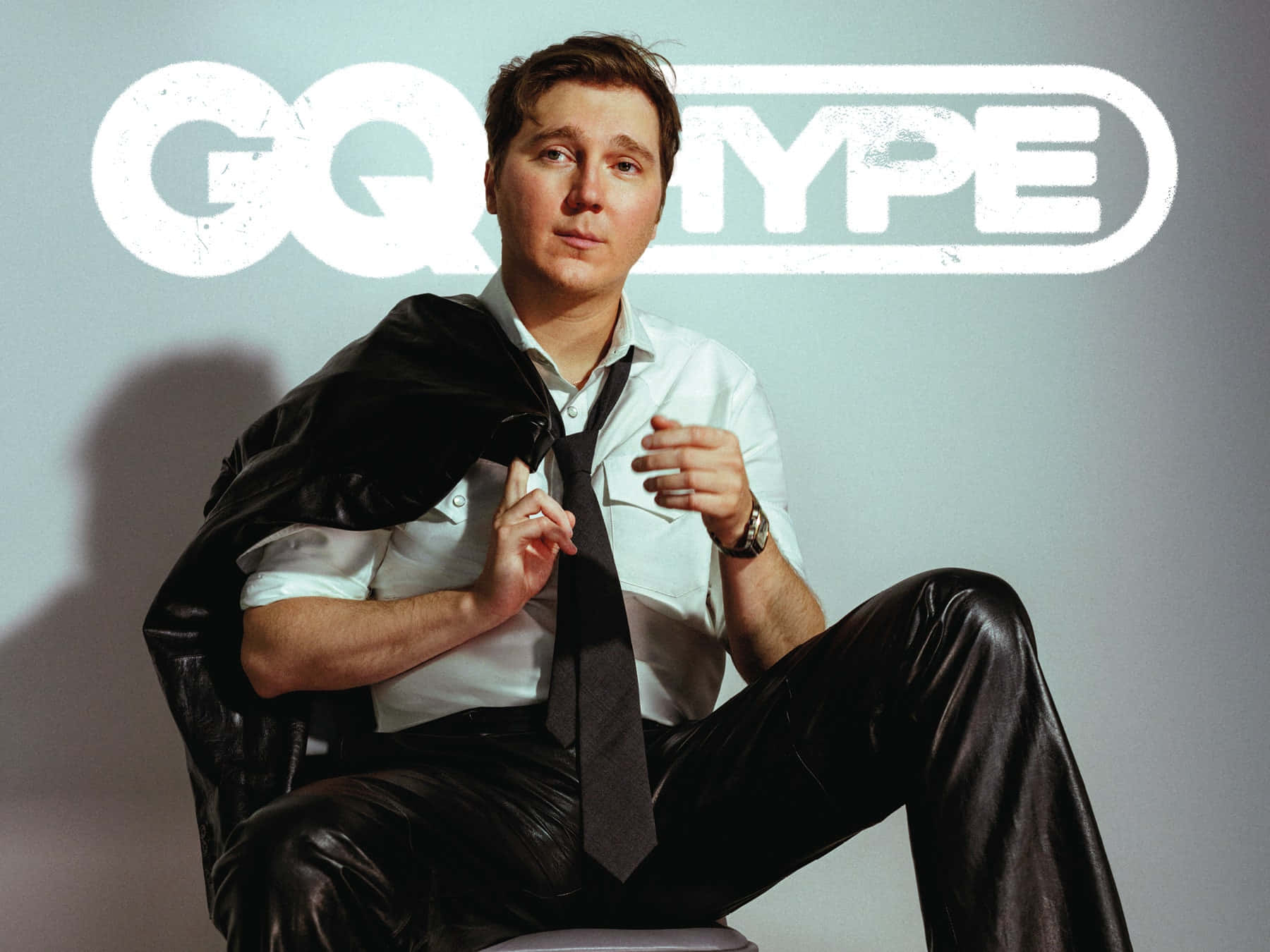 身穿皮褲和白襯衫的男子為GQ Type雜誌擺姿勢。