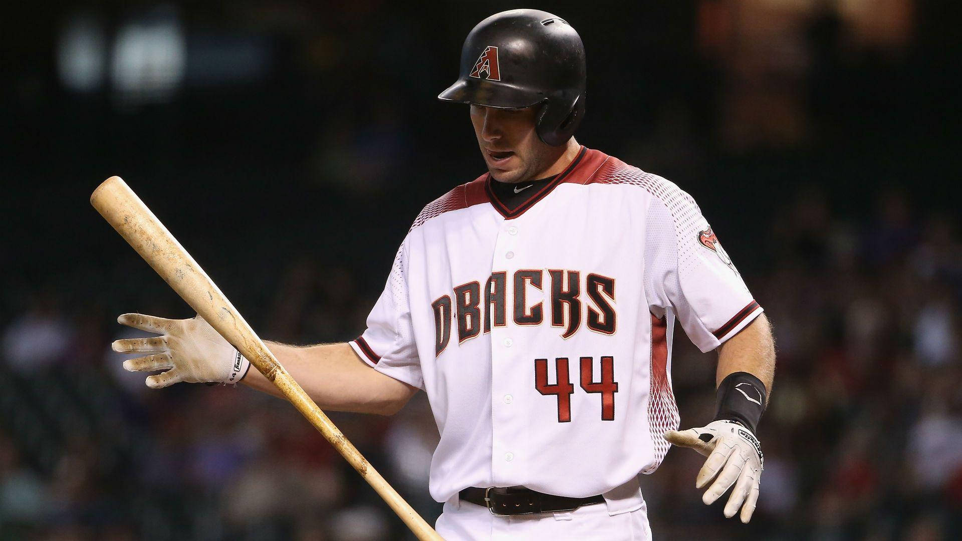 身穿Dbacks球衣的棒球手在夜間比賽中持棒。