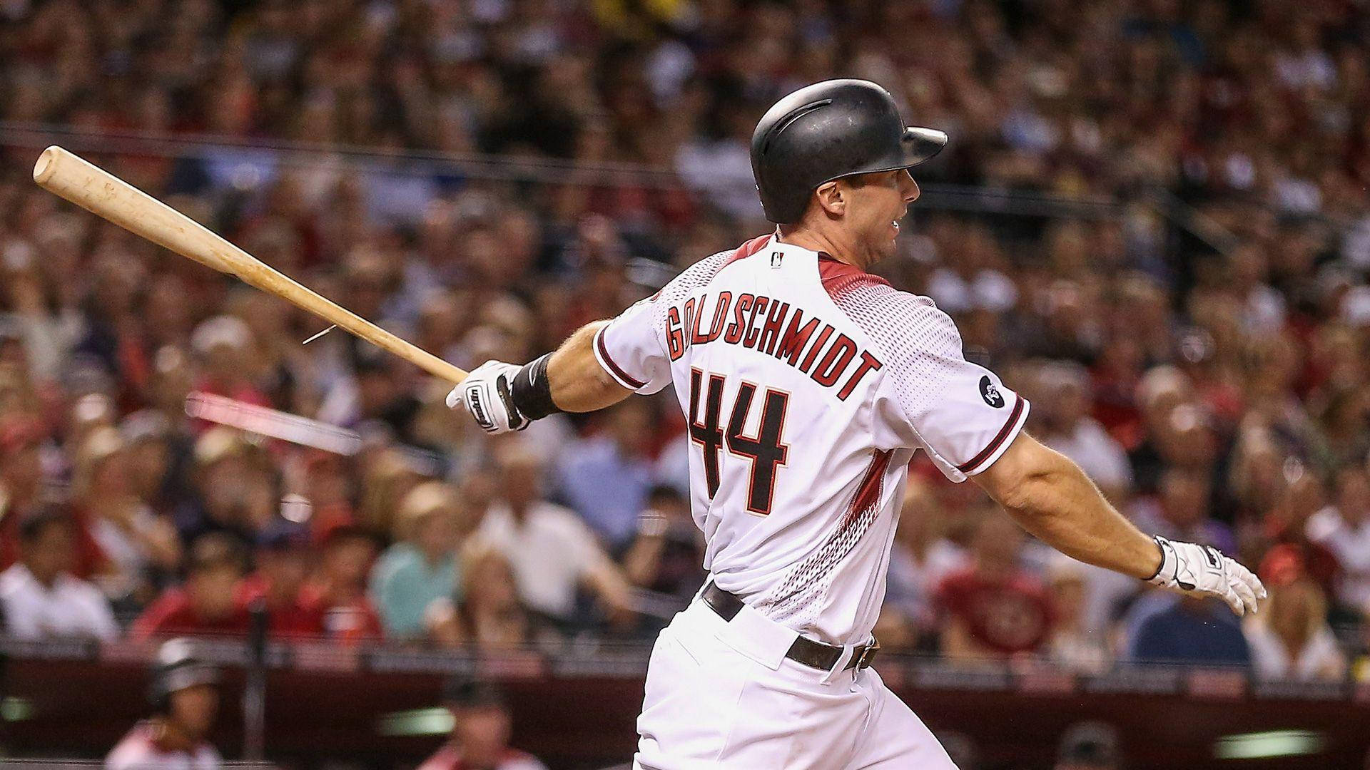棒球手Goldschmidt 44號在夜晚的球場揮棒。