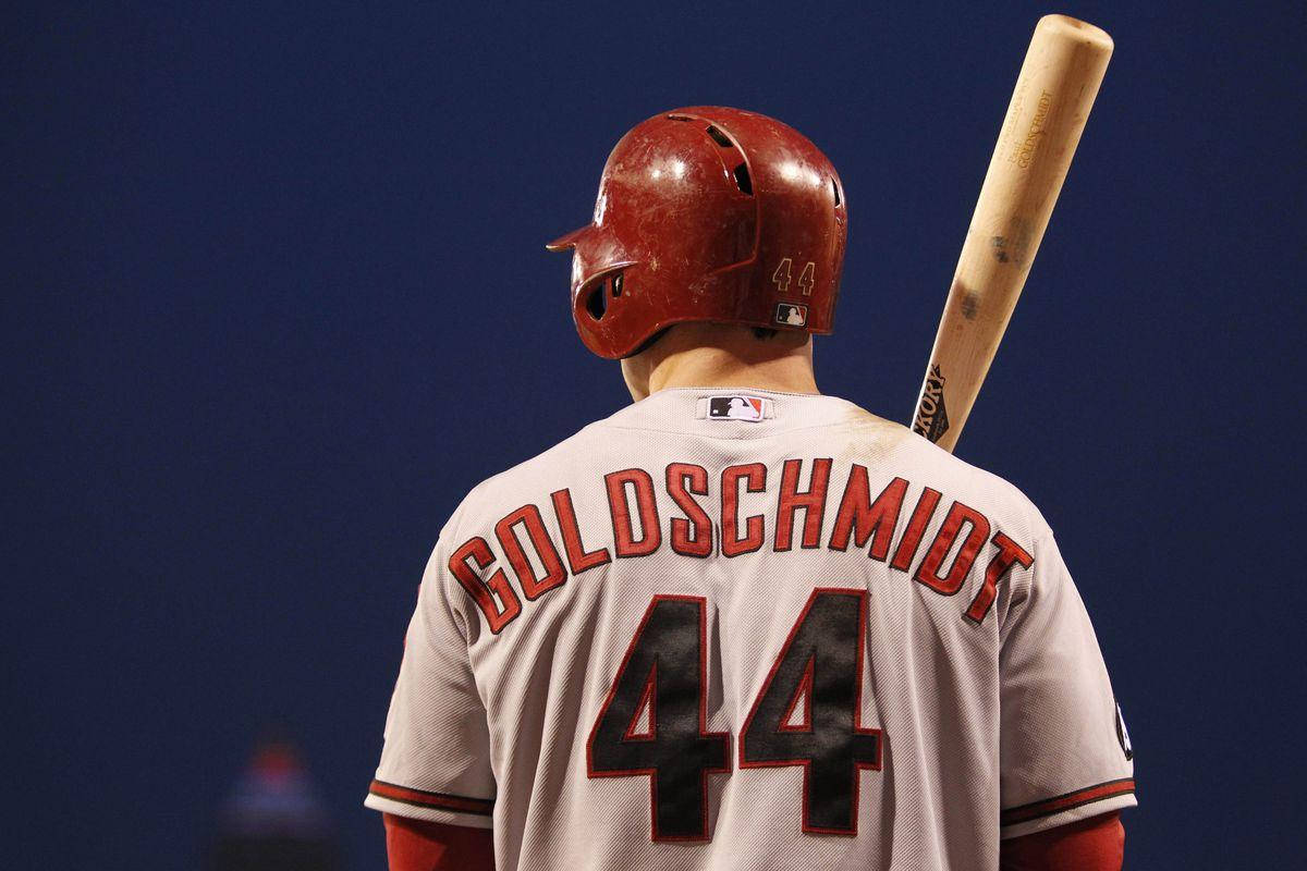 身穿球衣的棒球手Goldschmidt在夜間手持球棒。