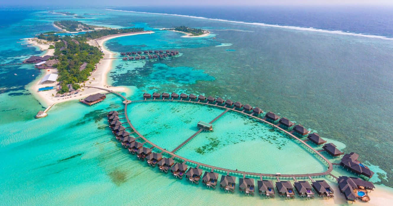 Maldives Island 桌布 壁紙 — 俯瞰豪華水上平房，位於碧綠海水環繞的熱帶島嶼，擁有白色沙灘。