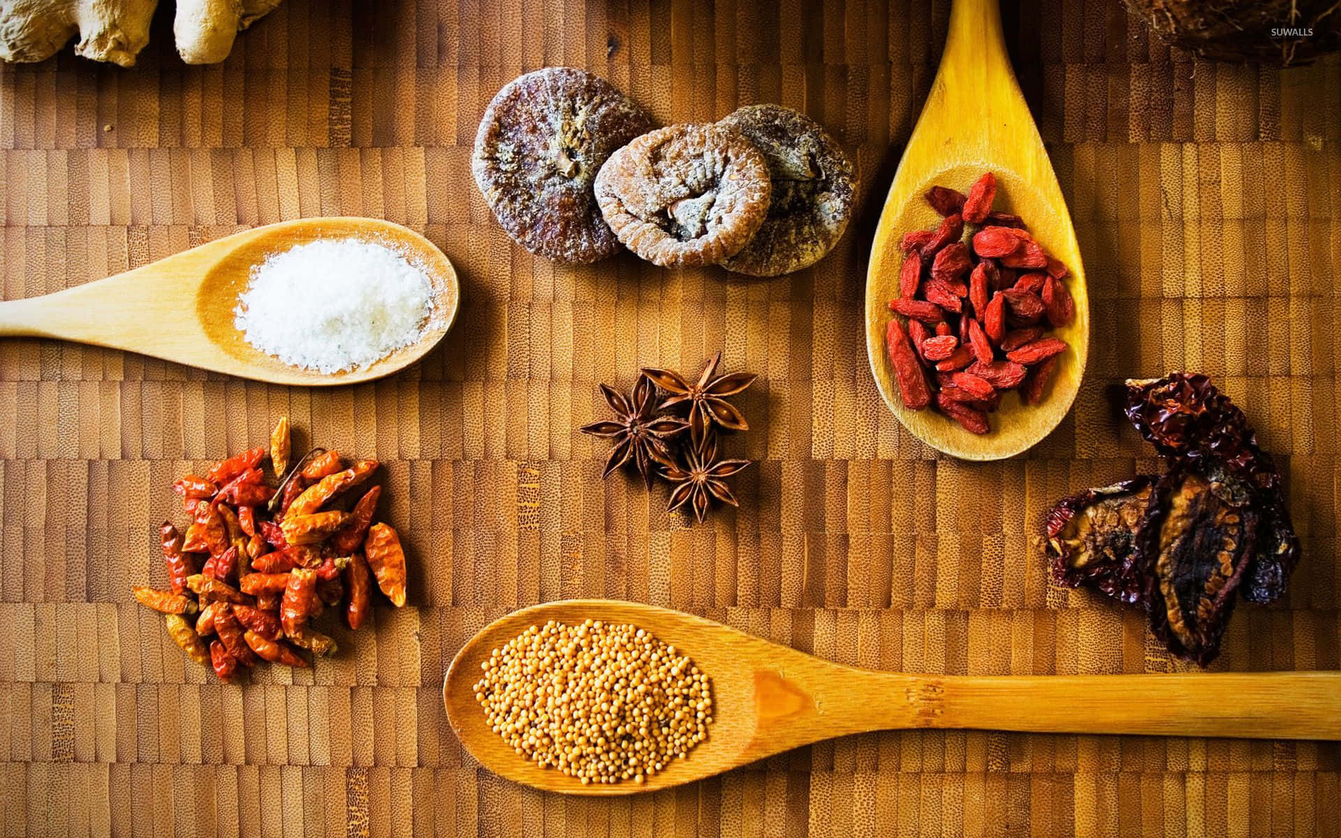 Spice 桌布 壁紙 — 俯視角度拍攝木匙和乾香料（如枸杞、八角、辣椒）整齊擺放在竹編墊上。