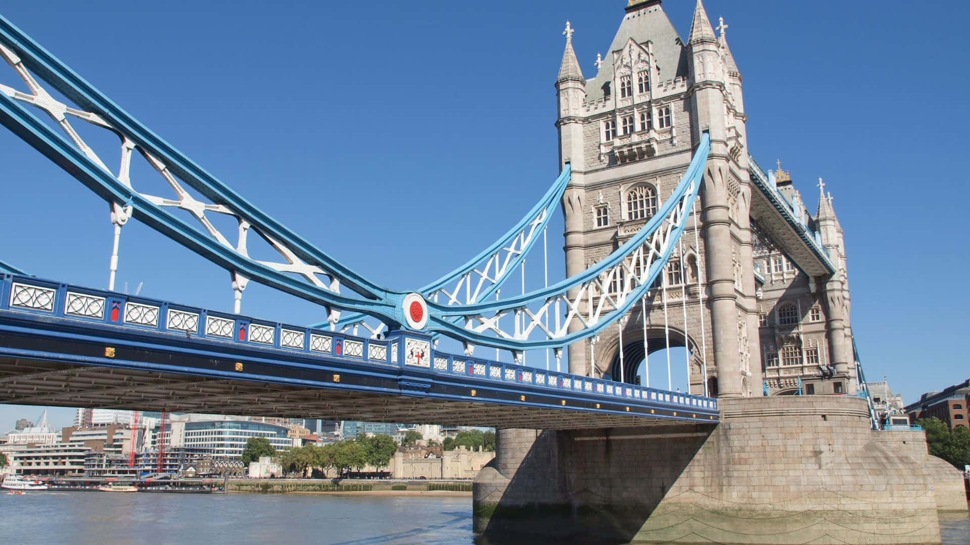 UK 桌布 壁紙 — 倫敦標誌性的塔橋在晴朗的藍天下，以其藍色的懸索結構和石塔，雄偉地矗立在泰晤士河上。