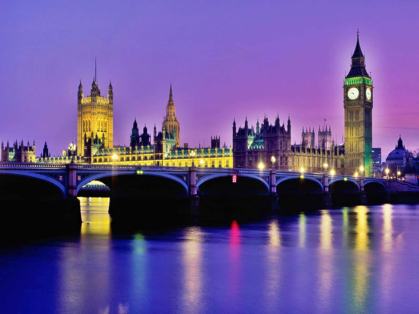 England 桌布 壁紙 — 倫敦標誌性的大笨鐘和國會大廈在黃昏時被鮮豔的紫色和金色燈光照亮，倒映在泰晤士河上。