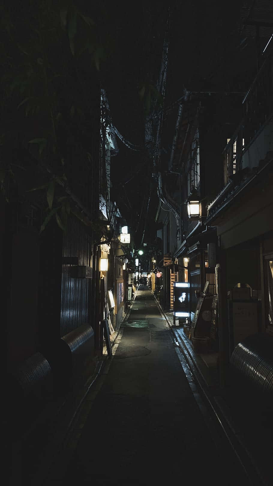夜晚昏暗的狹窄小巷，掛著燈籠和傳統建築。